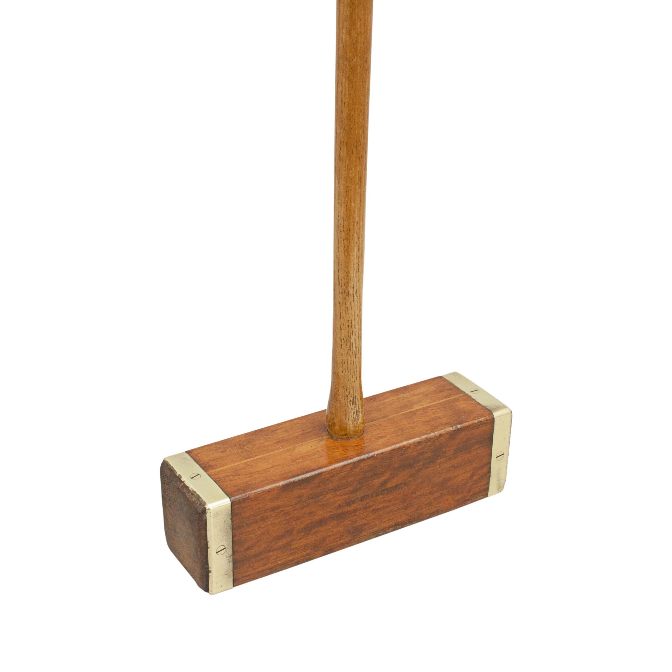 Square croquet mallet, the colonial.
A singular brass bound, square head, croquet mallet made by John Jaques. The mallet head is made from hardwood with circular face markings, an inlaid alignment guide and an octagonal hickory handle. The handle