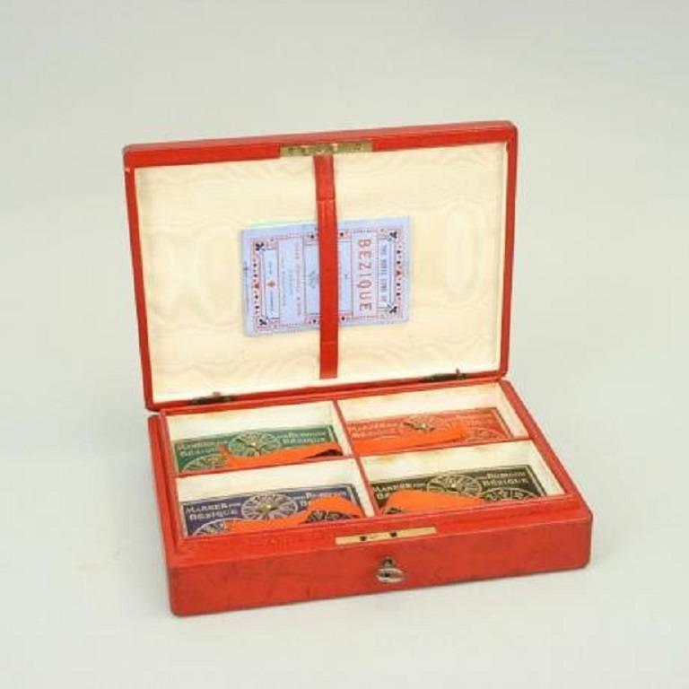 Vintage Goodall & Son bezique card set.
Bezique card game in a red leather covered box with gilt tooling to lid with a key and working lock. The box contains four sets of bezique cards (Ace, 7, 8, 9, 10, Jack, Queen and King) a booklet of the
