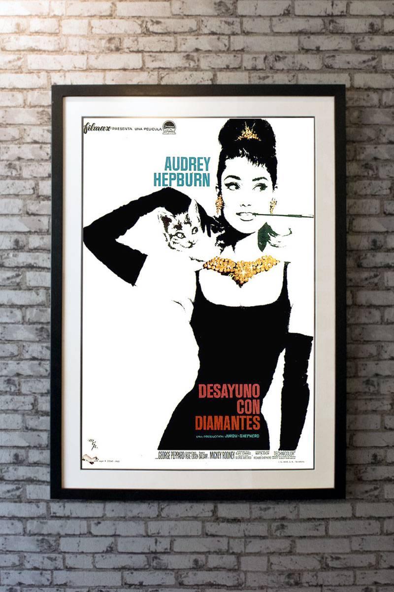 Audrey Hepburn is unforgettable as Truman Capote's iconic character Holly Golightly, sumptuously bejeweled and attired in the famous black Givenchy dress on this very rare Spanish one sheet. Spanish artists MCP (Ramon Marti, Joseph Clave, Hernan