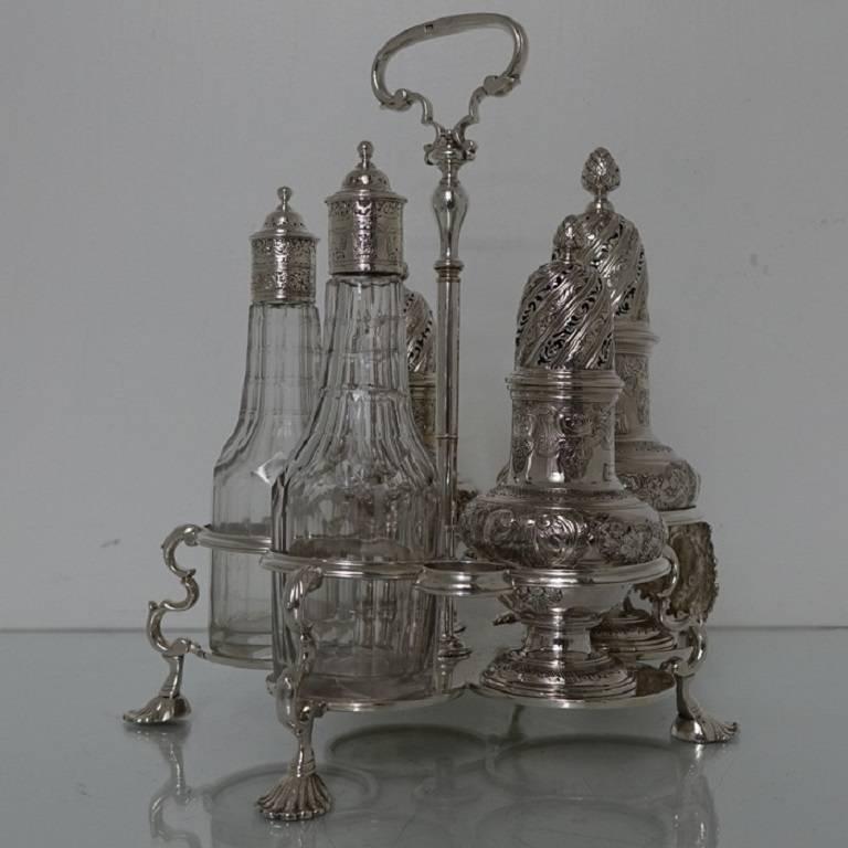 A very rare five condiment Warwick cruet, the salt, pepper and sugar caster have been elegantly flat chased for decoration. The oil and vinegar bottles have beautiful decorative contemporary glass with the detachable lids been also flat chased. The