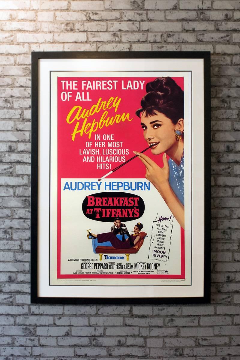 A monumental one sheet from an equally magnificent film. This rare US poster has the iconic artwork for Audrey Hepburn’s most popular film! Skillfully adapted from the Truman Capote novella, this darling movie had it all...wit, romance, humor, New