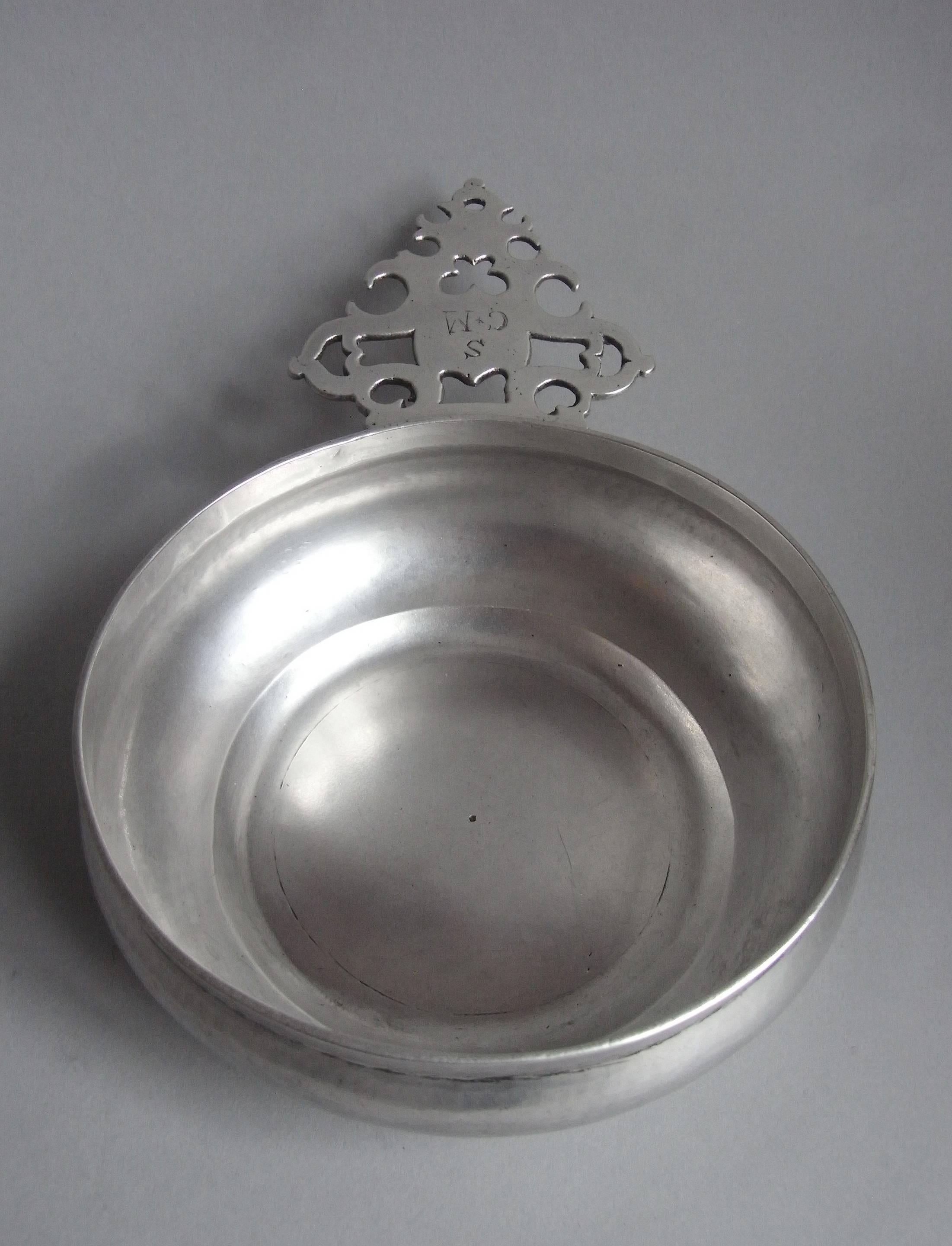 These side handled bowls were almost certainly used as eating vessels.  This exceptional example is made in the higher Britannia Standard grade of silver. The bowl has circular baluster sides which raise to a straight rim. The cast handle is shaped