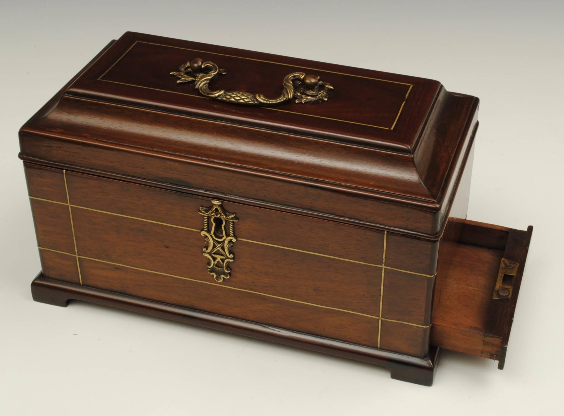An 18th century mahogany tea caddy with brass inlaid decoration in the manner of John Channon with the original fitted interior.