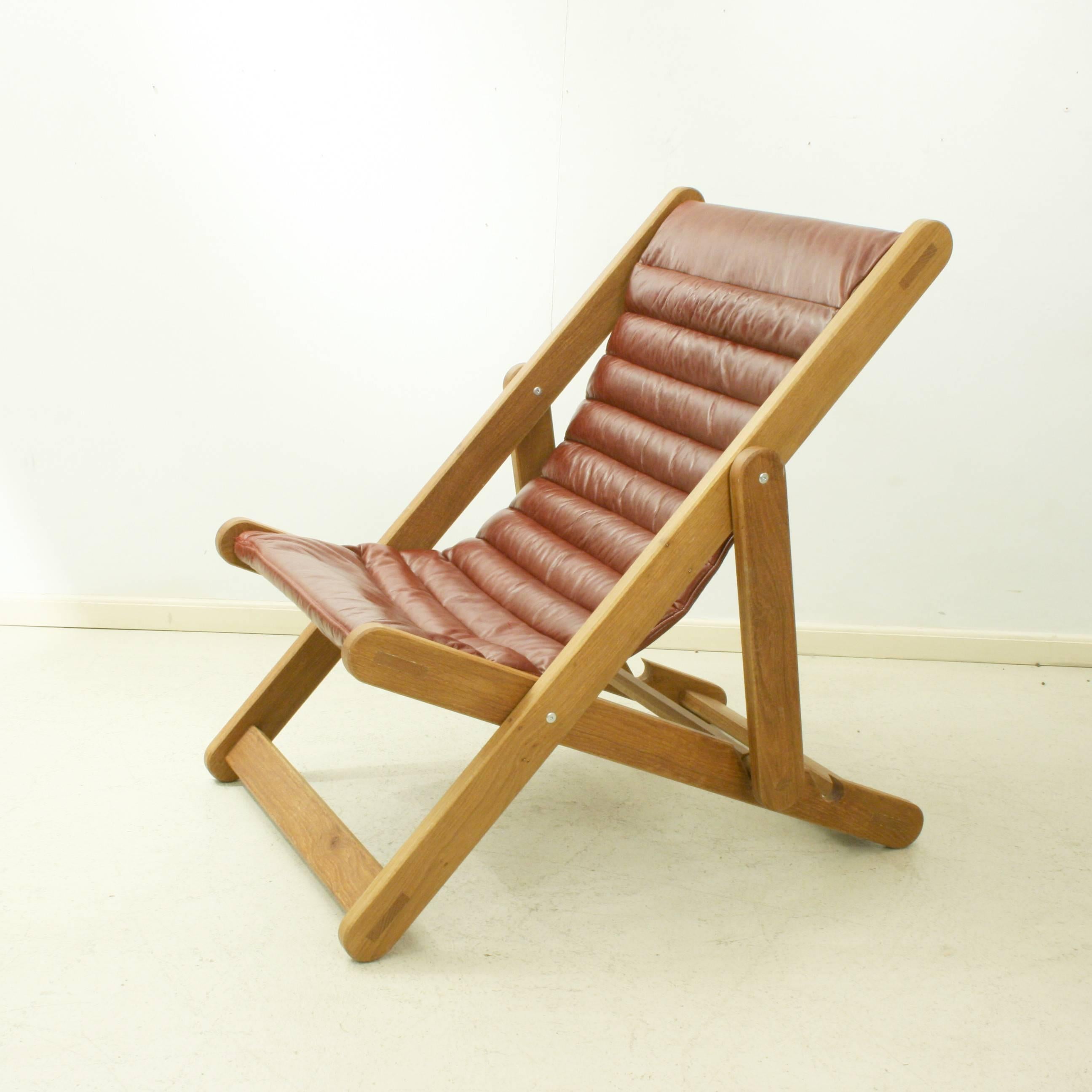 An extremely sturdy leather covered deck chair made with an oak frame. This is a heavy duty Traditional design English deck chair with two seating positions. The chair is very comfortable as the red leather sling seat is with extra padding. A