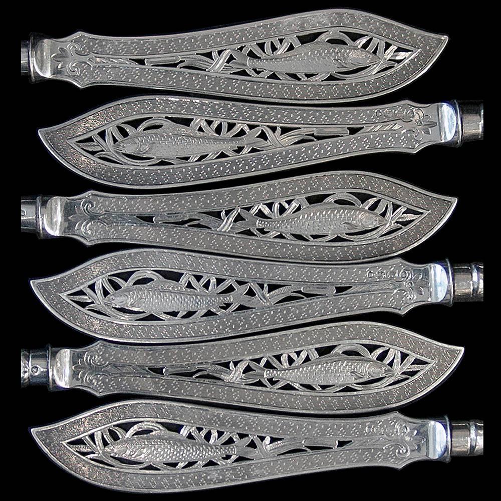 A superb set of silver handled fish eaters for six people, the handles of antique Grecian pattern and the hand pierced blades and forks finely engraved with fish and water plant design.