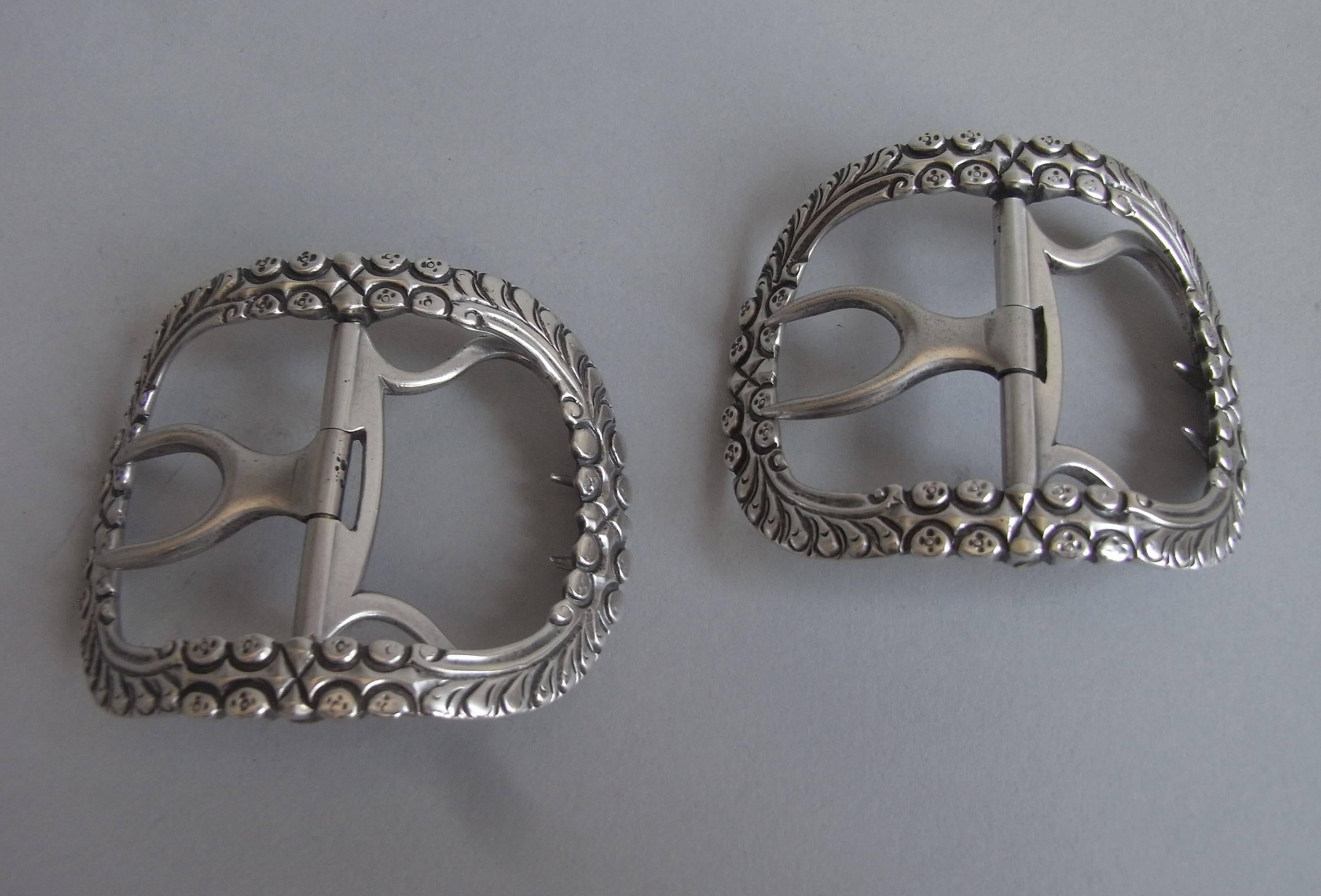 The Buckles are of arched form and the openwork frames are unusually chased with roundels and feathery scrolls. The frames are backed by solid silver chapes, which is a most unusual feature as most are made of steel at this date. The quality of