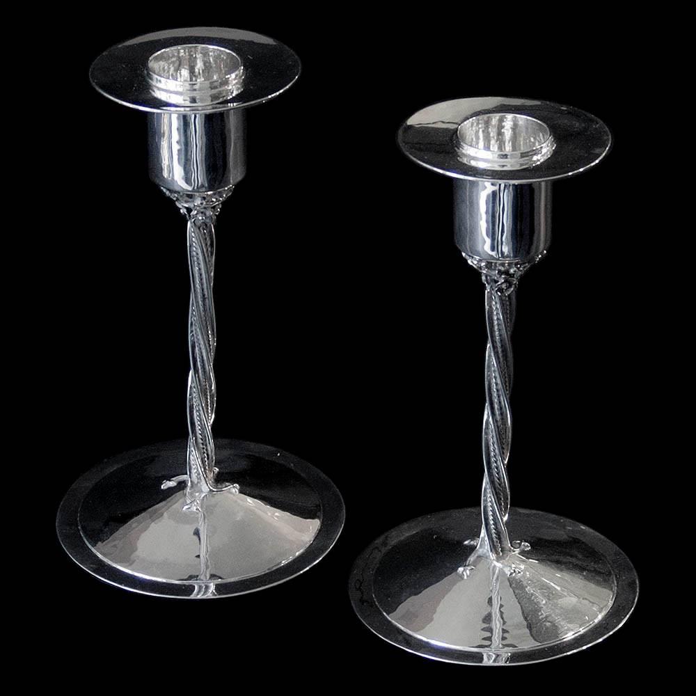A very interesting pair of silver candlesticks by Charles Boyton. The twisted decorative columns mounted on hand-hammered circular bases supporting hand-hammered sconces. Each base inscribed with the signature Charles Boyton.