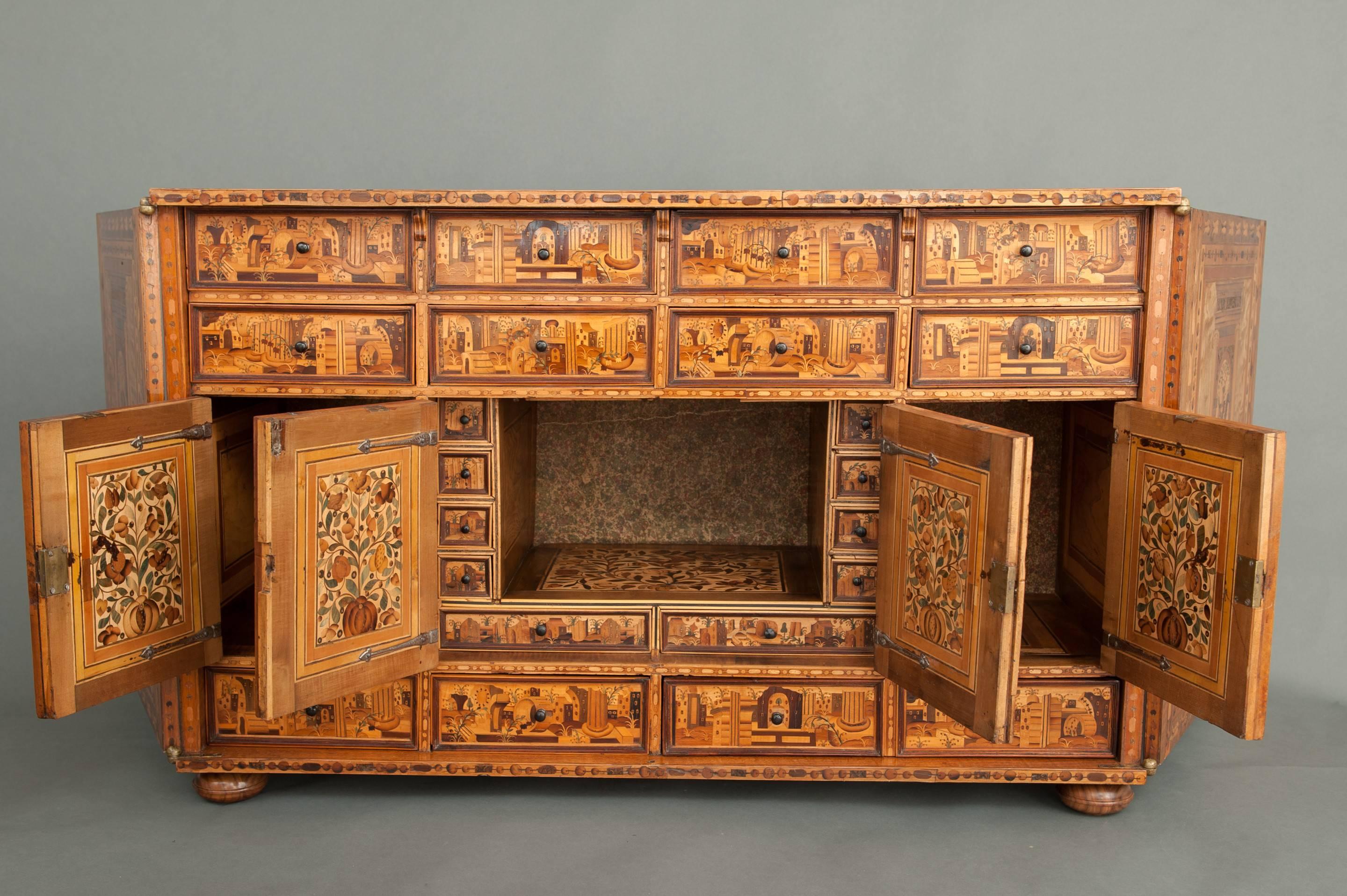 A superb example of an Augsburg Hungarian ash marquetry two door table cabinet. The whole inlaid with architectural views with columns and landscapes, the two doors open to reveal a fully fitted interior again all beautifully inlaid. To the interior