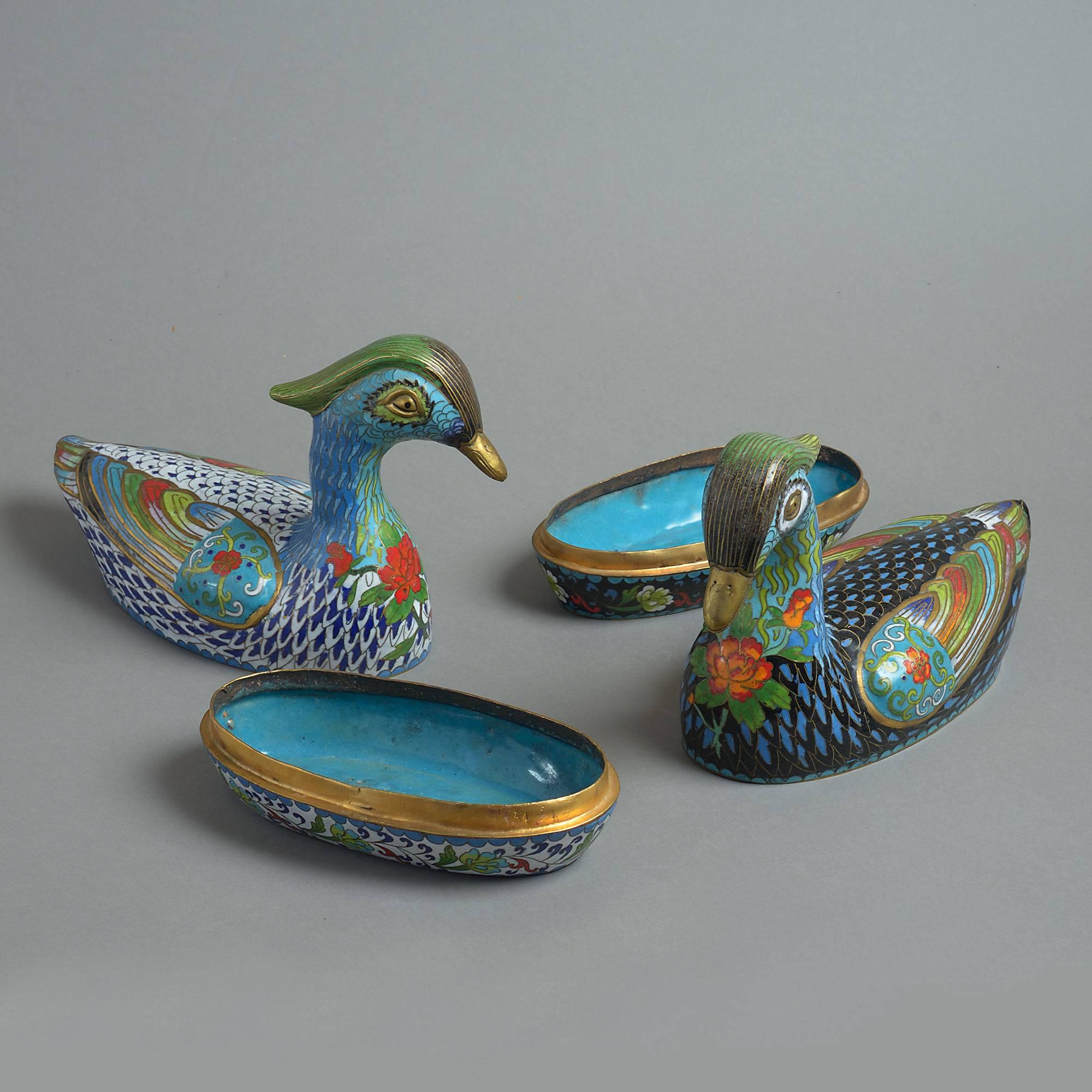 A early 20th century pair of cloisonné boxes taking the form of ducks, the lids lifting to reveal turquoise enameled interiors.