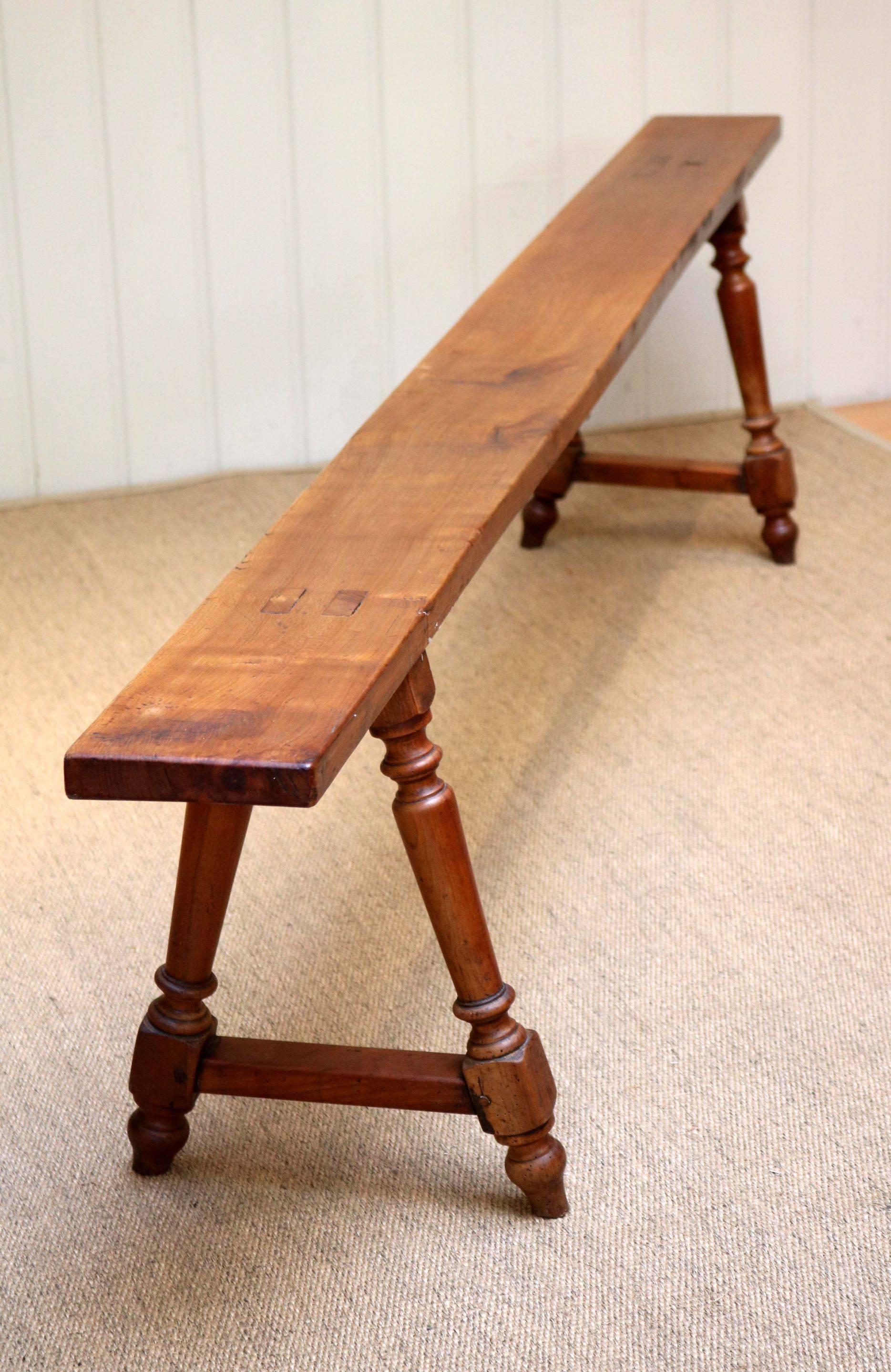 Late 19th century cherrywood bench having turned wooden supports to each end. Pair available.