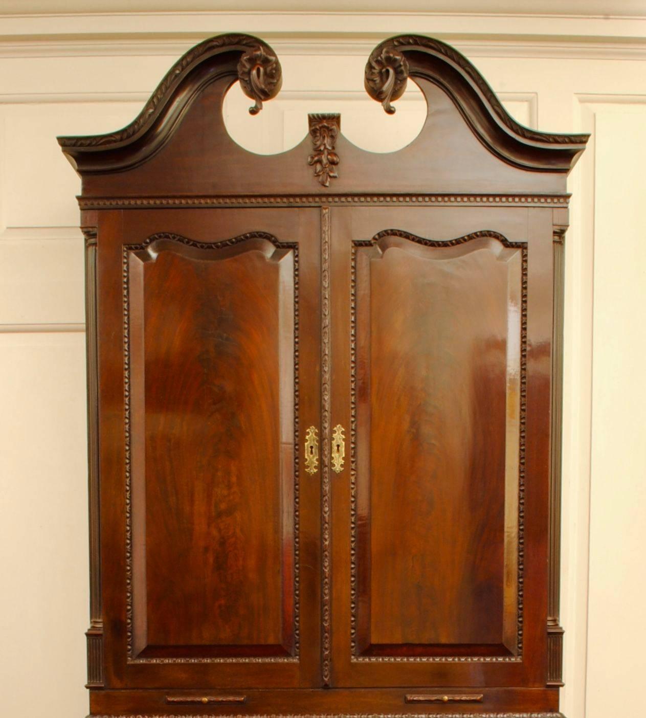 A rare example of an 18th century mahogany bureau bookcase, the whole with finely carved mouldings and a swan neck pediment above the two doors. Good flame mahogany to the doors, fall and drawer fronts, standing on well carved cabriole legs ending