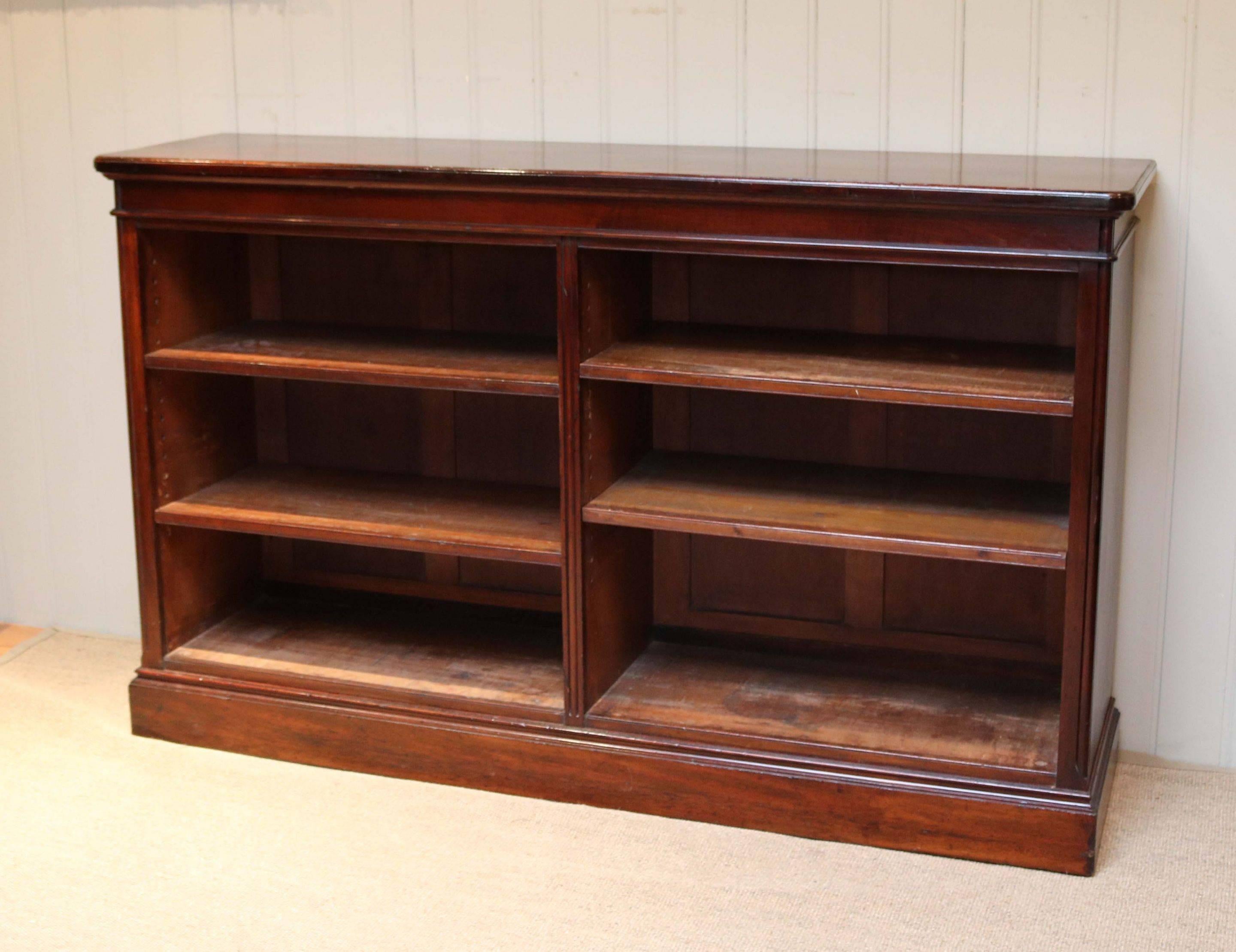 Substantial Victorian low open mahogany bookcase having four fully adjustable shelves in two sections. The top having a moulded edge and raised on a plinth base.