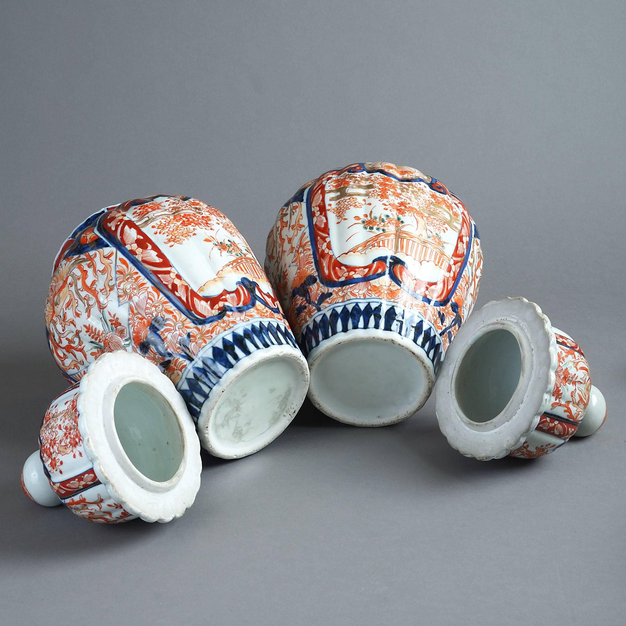 A late 19th century pair of Imari jars with covers, the bodies of ribbed form and decorated throughout with red, blue and gilt glazes upon white grounds.