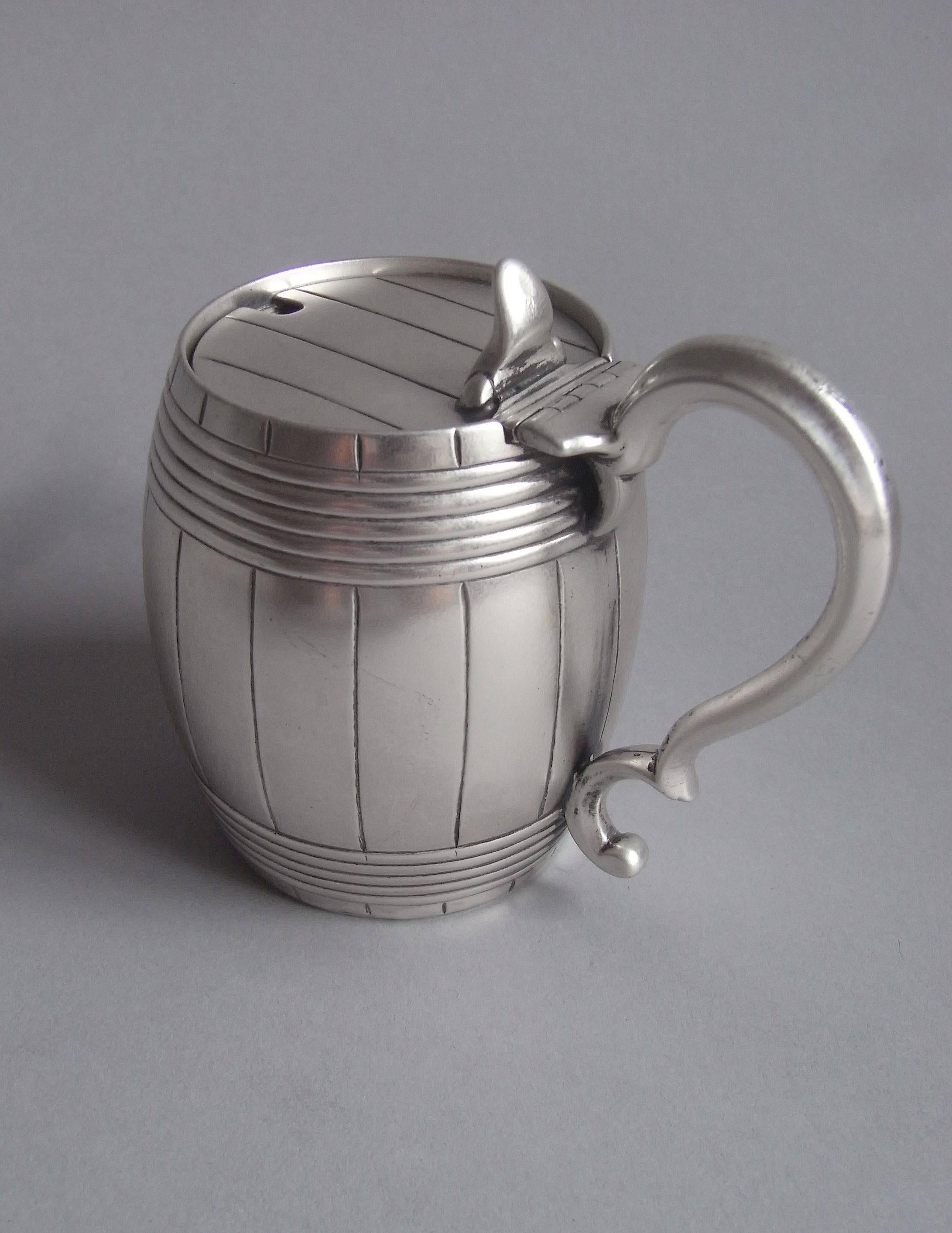 The Mustard pot is finely and realistically modelled as a barrel and is engraved with linear bands to simulate the planks and staves. The hinged cover has a cast scroll thumb pieces and the Pot has a plain scroll thumb piece. Fox barrel mustard pots