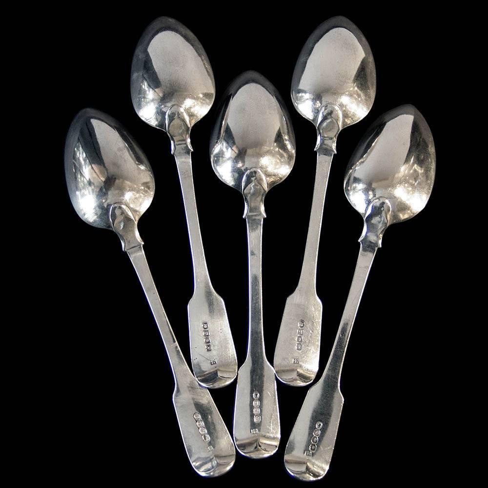 A good set of five George III sterling silver fiddle pattern table spoons each with original family crest.