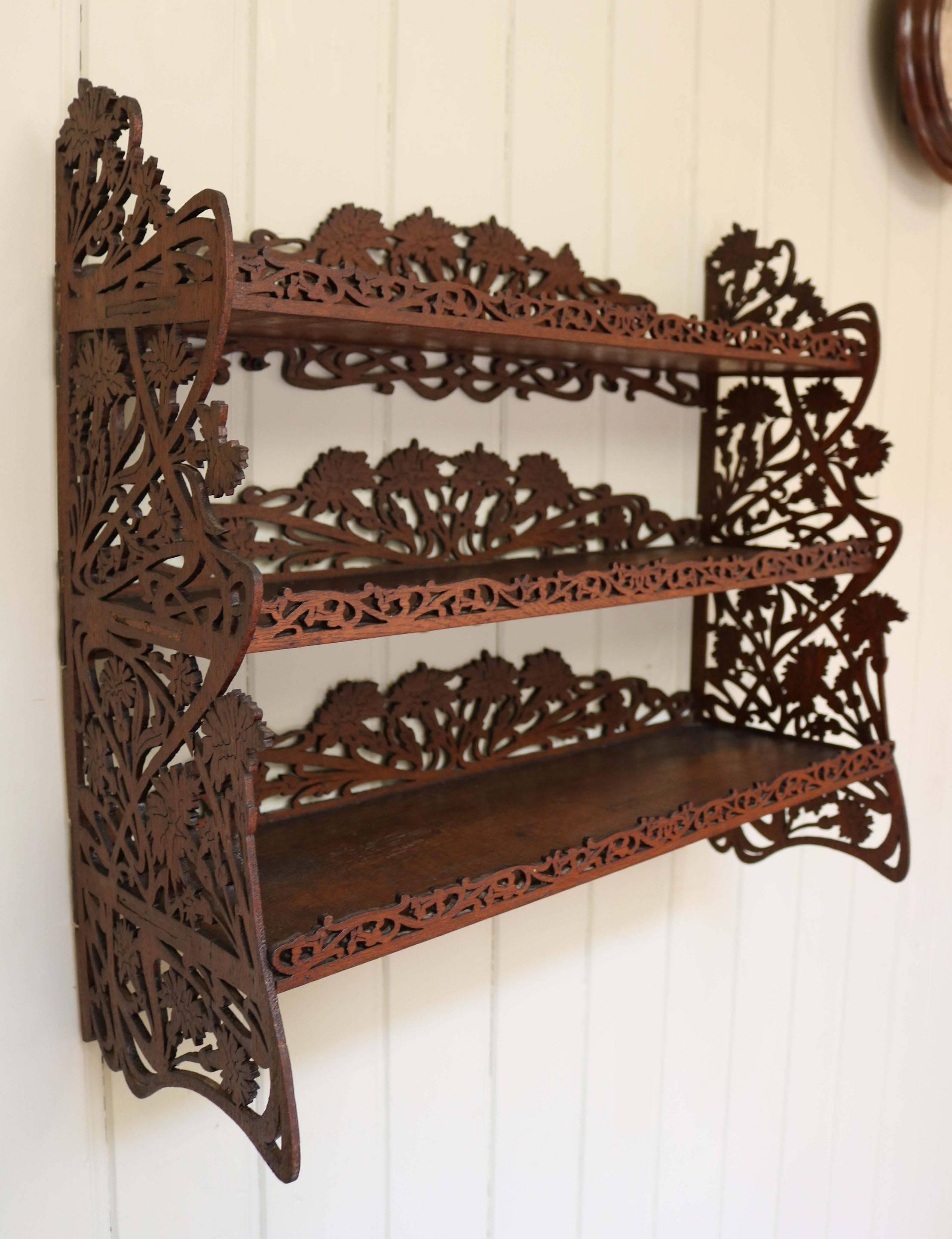 Mahogany three-tier fretwork shelf having three graduated shelves with fret fronts to each with fret decoration to the rear and a floral fret design to the edges.