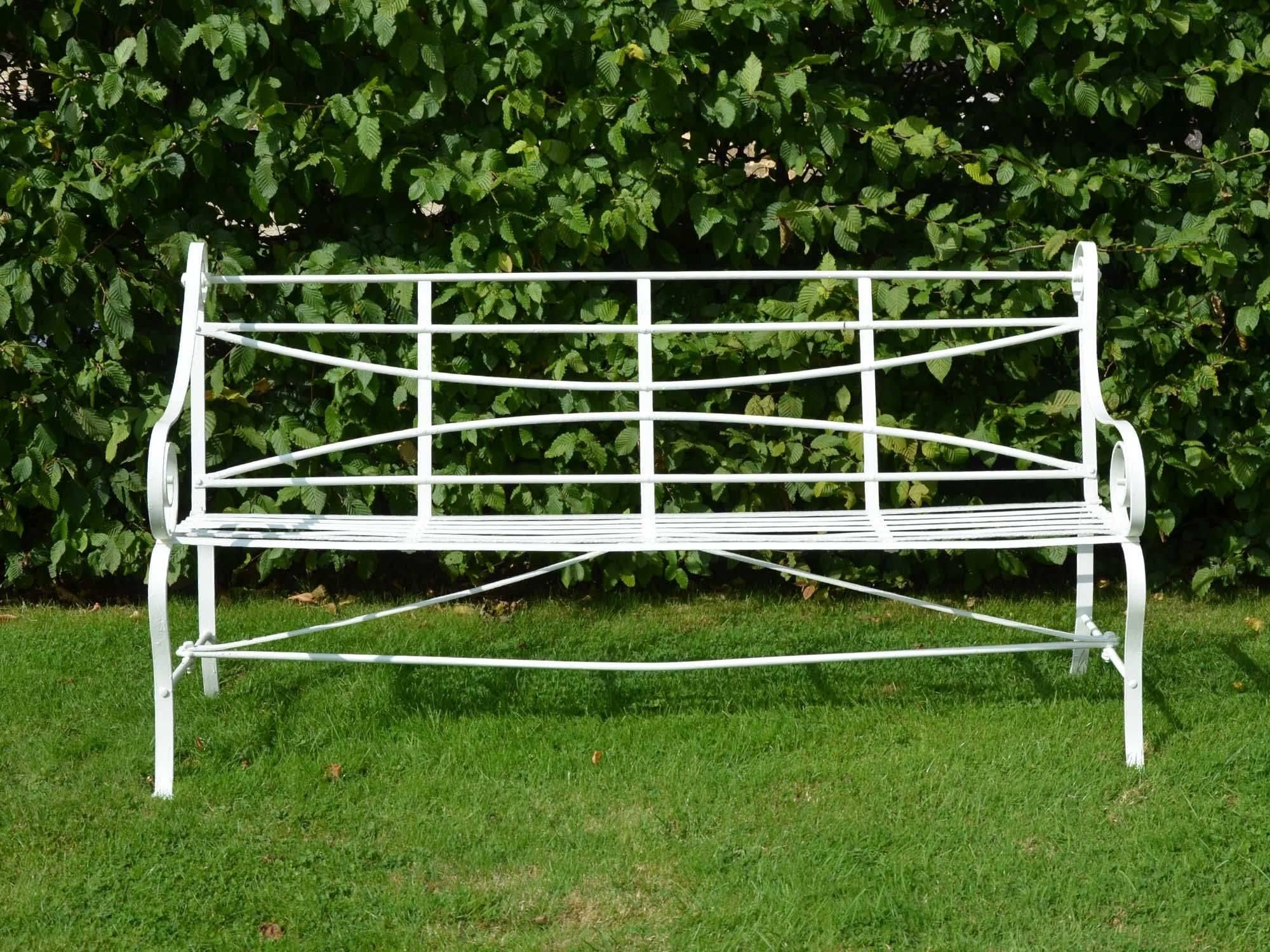 A 19th century wrought iron strap work garden seat having cabriole legs and scroll arms.