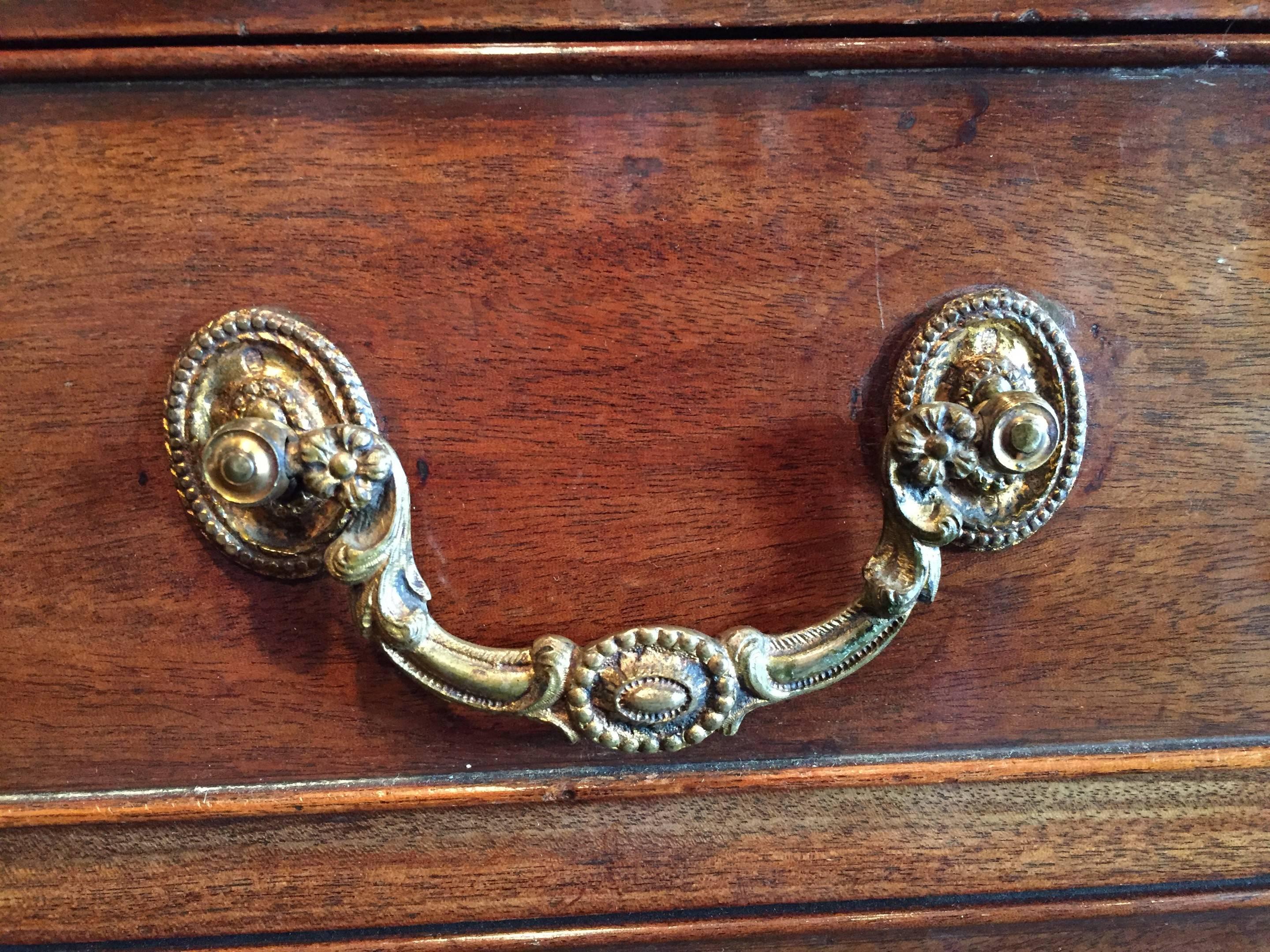 A fine George III period patinated and figured mahogany chest of drawers in the Chippendale style. The chest retains its original shaped brass handles and escutcheons.
The rectangular moulded top above four oak lined drawers which are flanked by