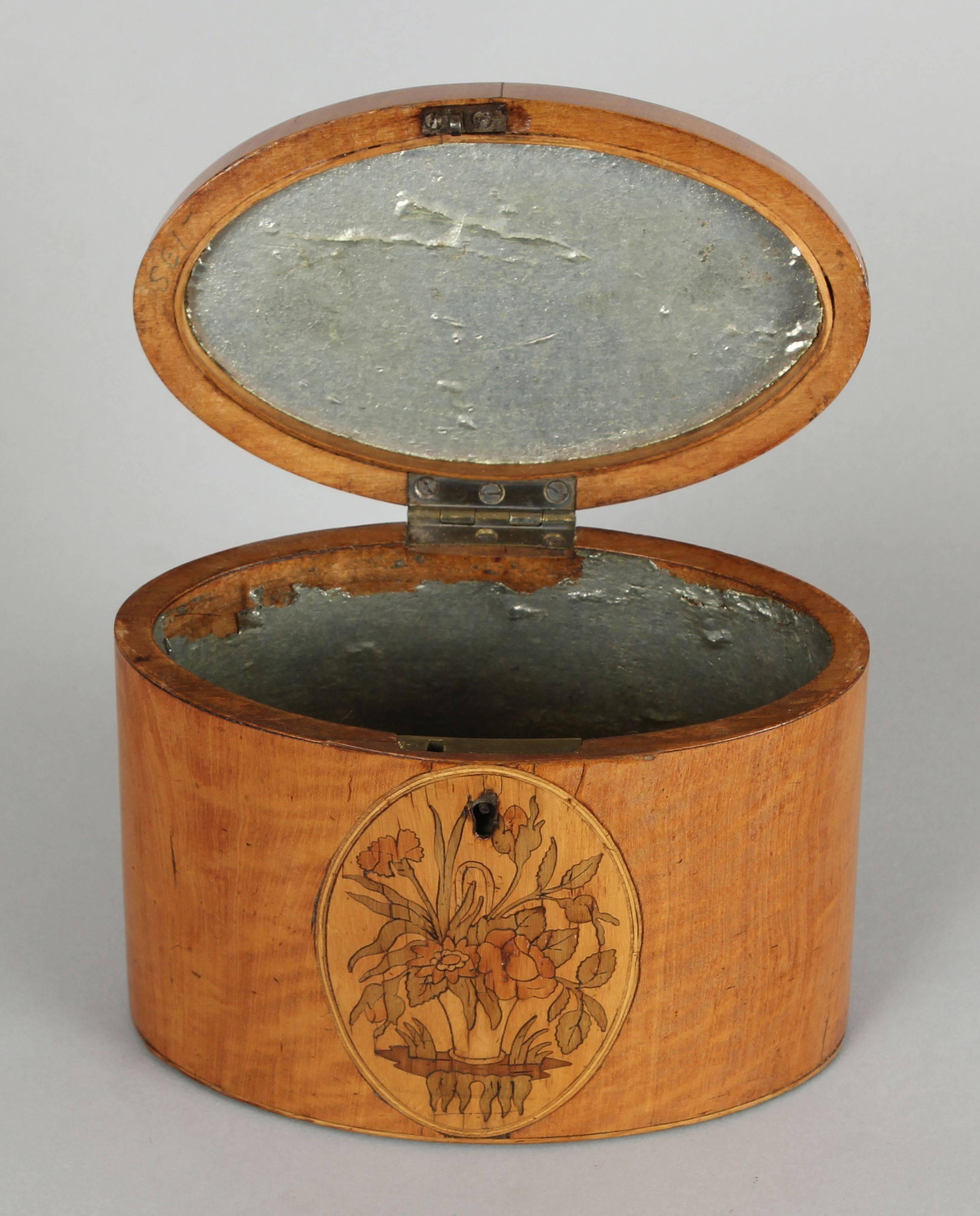 George III period satinwood oval tea-caddy with inlaid panels of flowers and a stylised shell.
