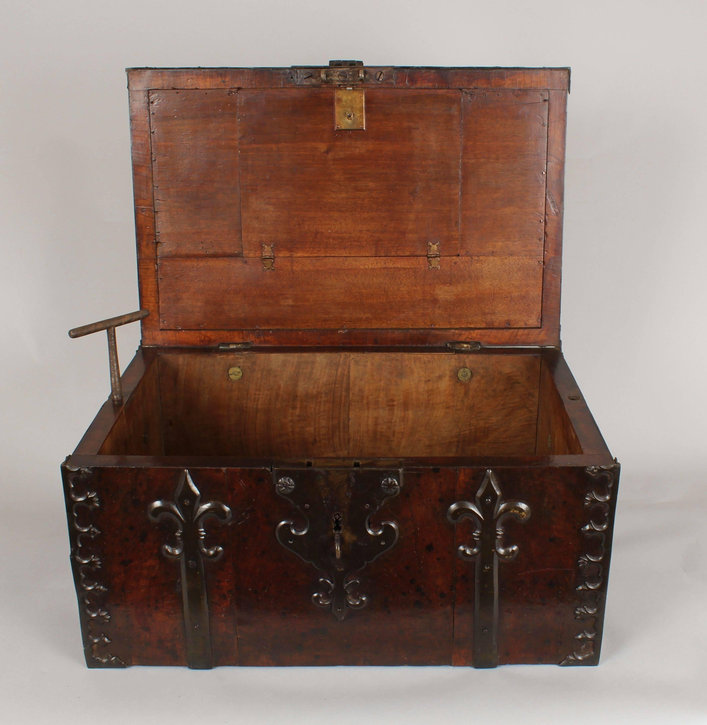 17th century, walnut coffre-fort; the heavily constructed box elaborately mounted with cut-steel straps, handles and hasp; the interior with a compartment within the lid and a pair of screws to enable the box to be secured to the floor or other