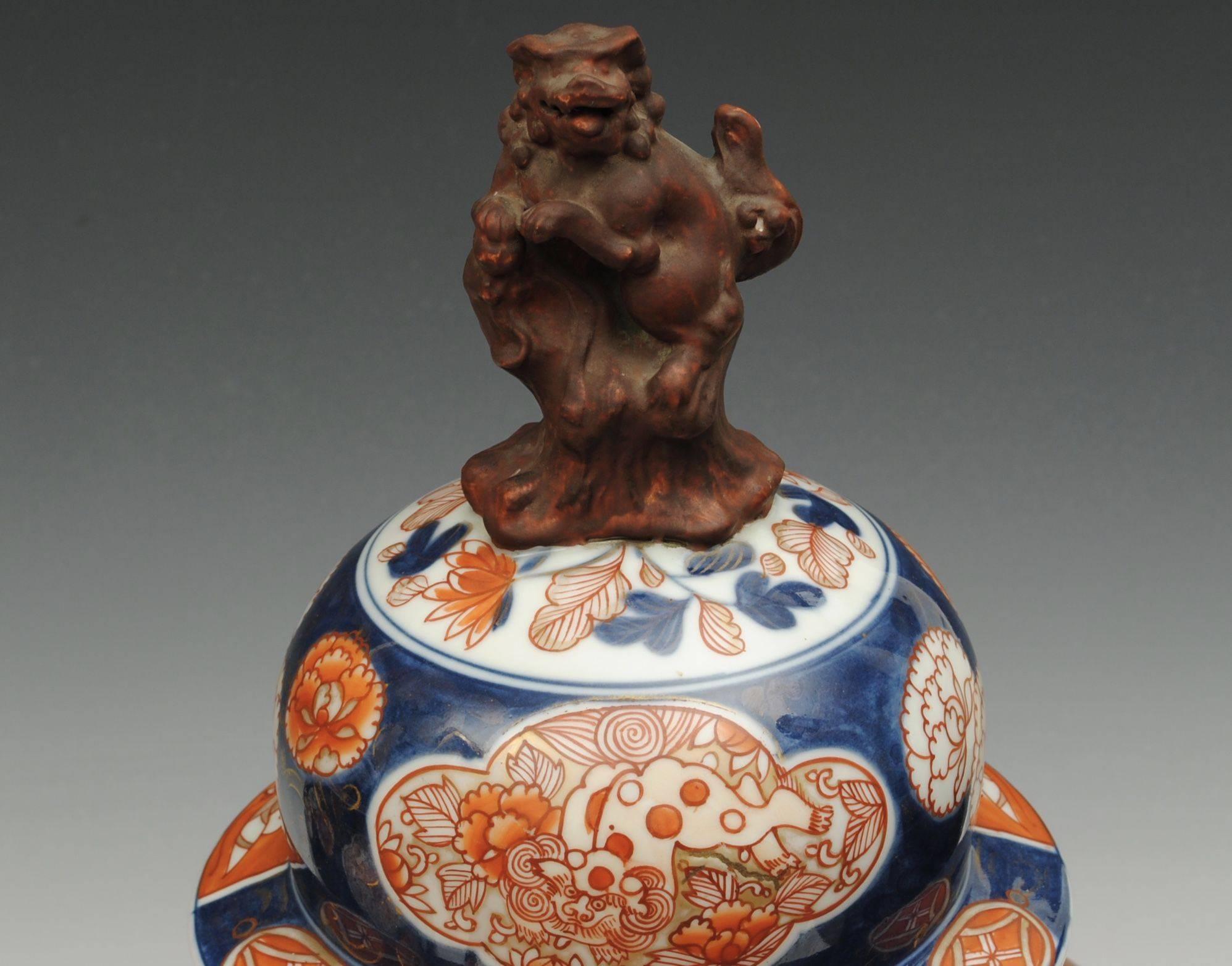 A good pair of 18th century Japanese Imari vases and covers with the original dogs mounted on the lids.