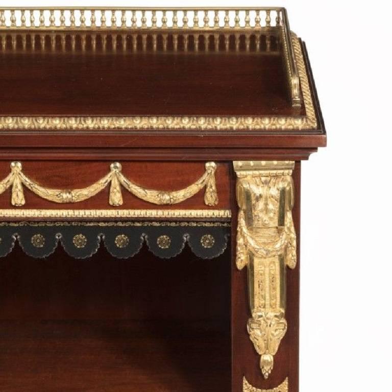 An unusual late Victorian mahogany and gilt bronze-mounted open bookcase, with ormolu feet and gallery. Two adjustable leather fronted shelves, English, circa 1890.
