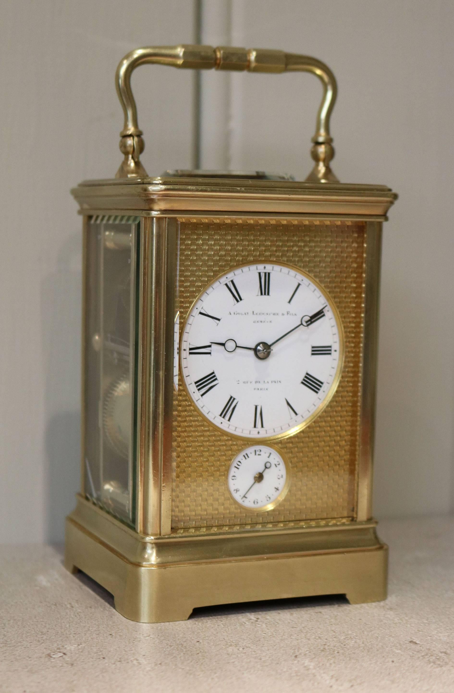 A fine mid-19th century polished brass carriage clock. It has a shaped top handle and a thick oval bevel edge glass. The engine turned gilt dial mask has an enamel dial and a subsidiary alarm dial. It is signed by the original retailers, A Golay