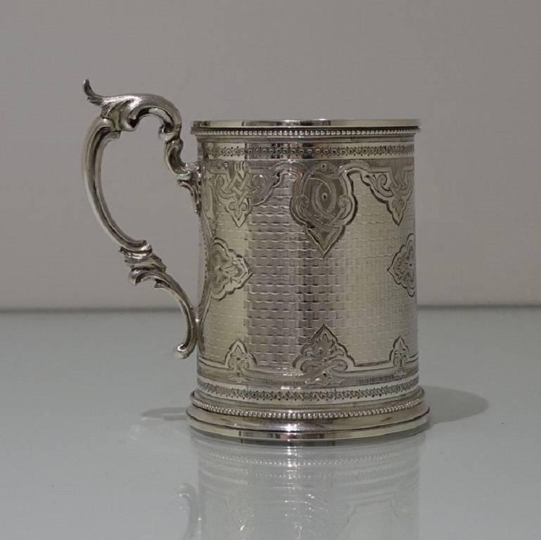 An extremely beautiful mid-19th century christening mug with upper and lower bead borders for low/highlights. The mug has been elaborate bright cut hand engraved throughout for decoration and has a double cartouche. The centre front of the mug has a