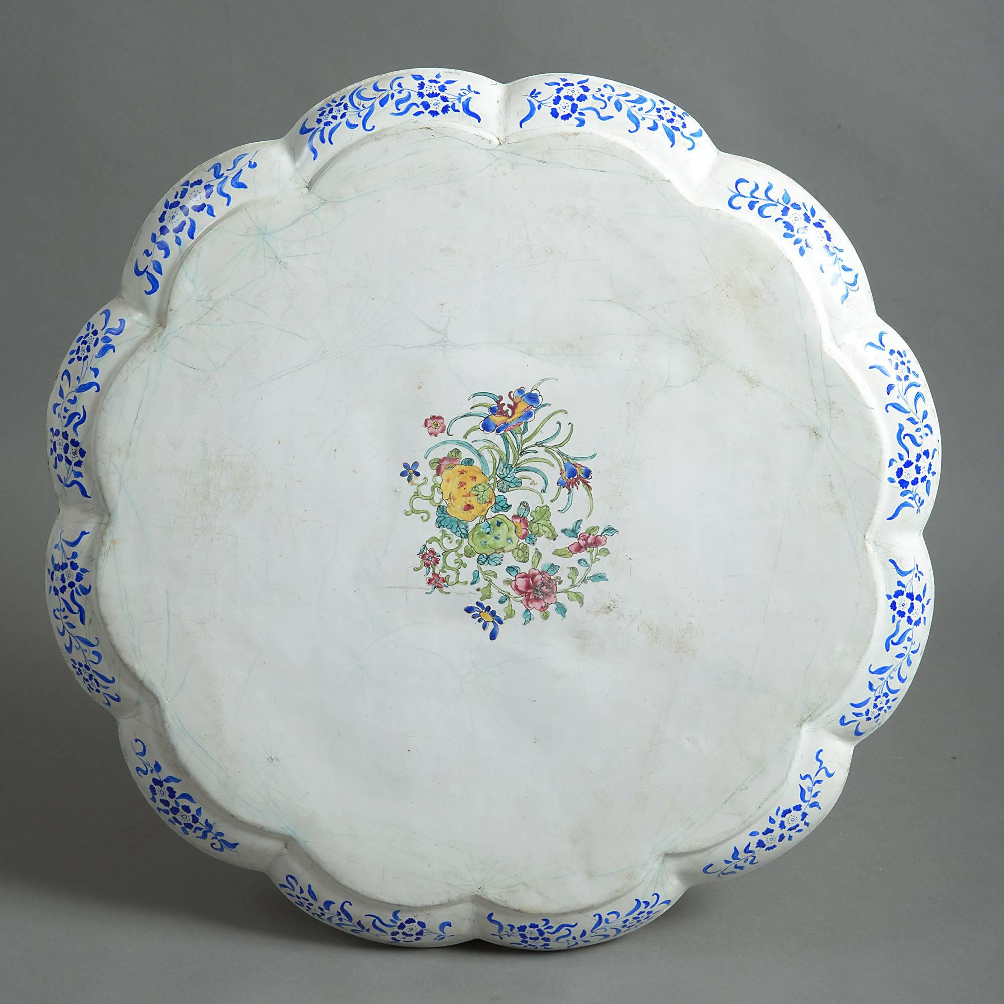An 18th century canton enamel charger of great scale, having a scalloped edge and decorated throughout with floral vignettes.