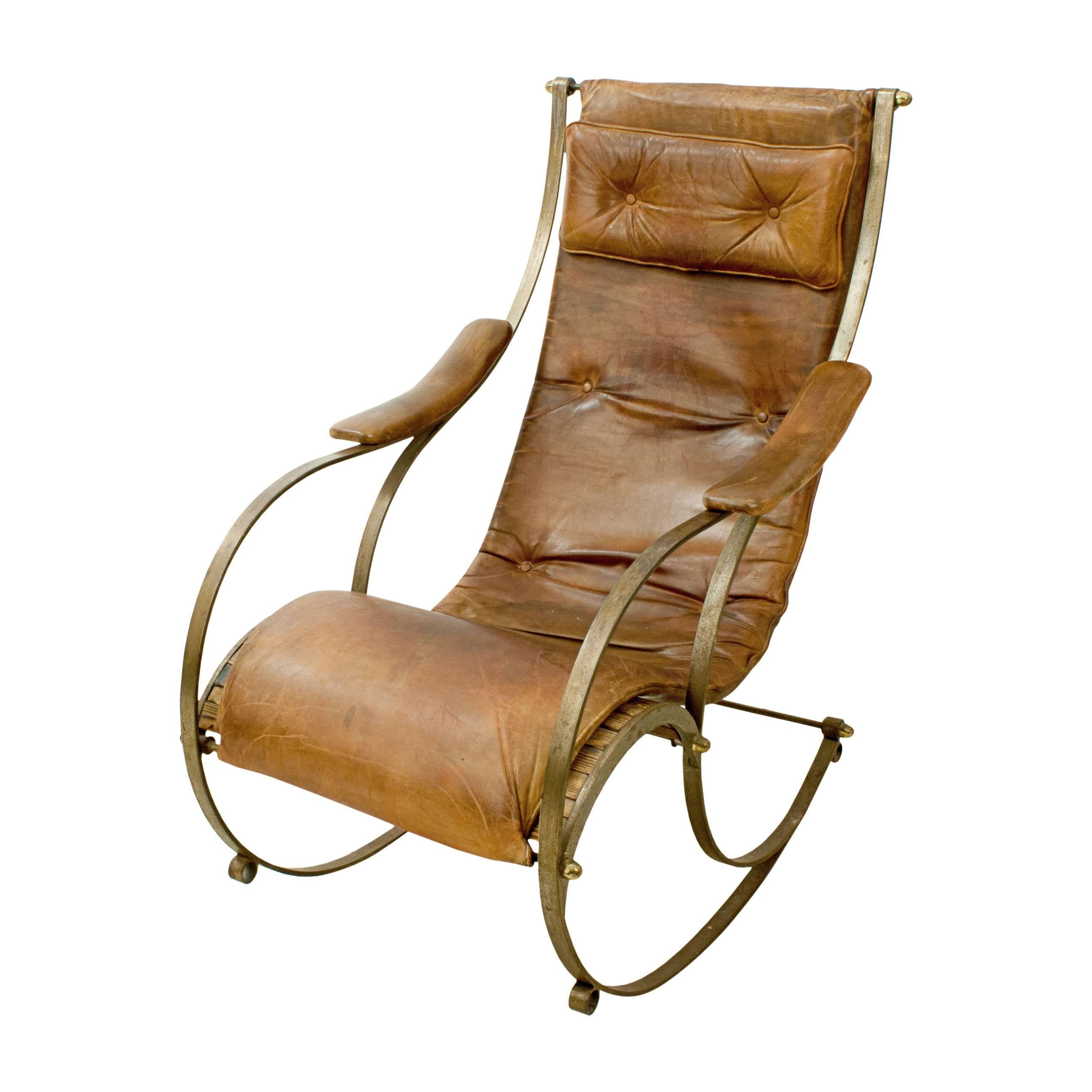 Rocking Chair, R. W. Winfield.
A late 19th century steel framed rocking chair after R. W. Winfield. The chair has a steel frame with brass fittings, padded leather armrests and a fixed upholstered padded tan leather button back cushion of a slung