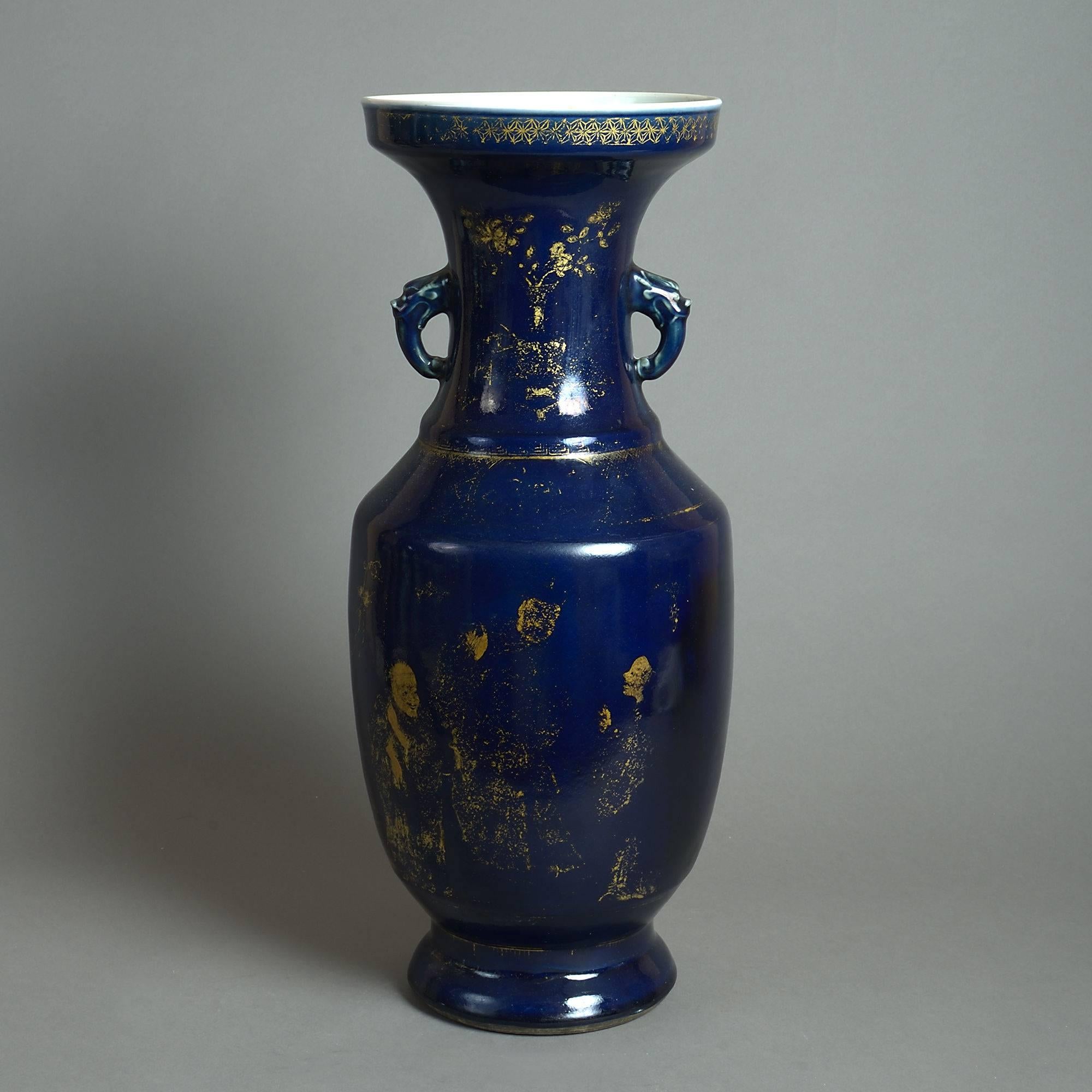 A late 19th century porcelain vase of large-scale, the trumpet neck with handles, the body with gilded decoration upon a powder blue ground. 

The body with restorations.