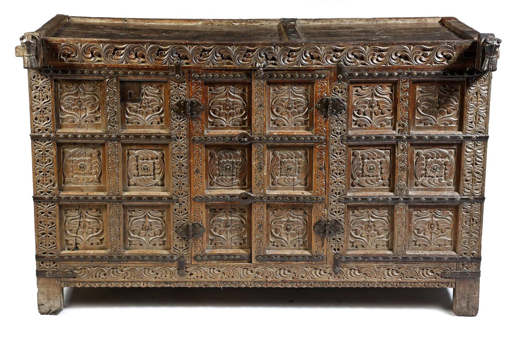 Anglo-Indian Damchiya Dowry chest
An Indian hardwood bride's dowry chest or Damchiya. The intricately carved and decorated cabinet is with iron strapping and brass diamond washers, the front corners carved with Primitive horse head finials. The