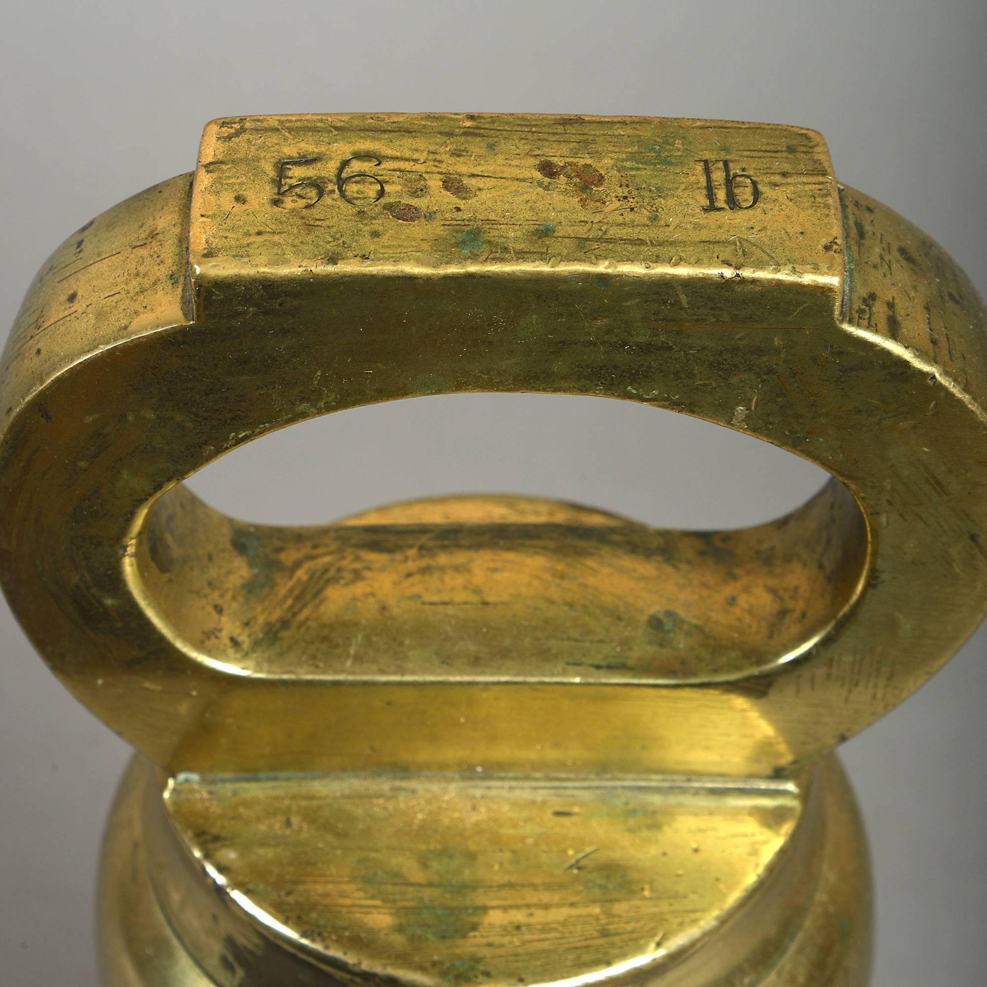 A 19th century official 1/2 CWT brass bell weight, inscribed 56lb 

Brass bell form weights such as these were used throughout the United Kingdom and British Empire in Government offices during the 19th and early 20th centuries. They have a