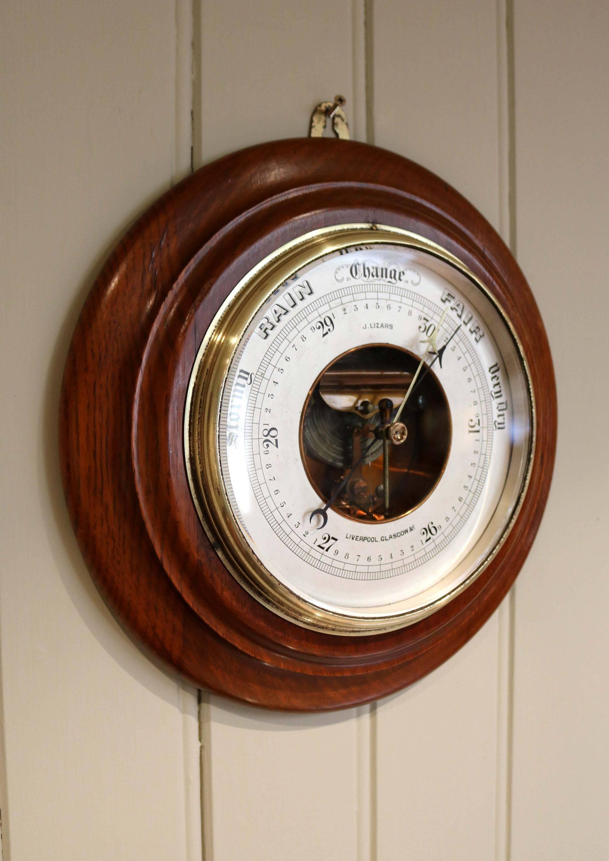 Large circular oak aneroid barometer having a silvered dial signed J Lizars Liverpool & Glasgow with a visible movement. John Lizars worked between 1858-1900 some of his barometers were made using oak from the Royal Exchange which was destroyed by