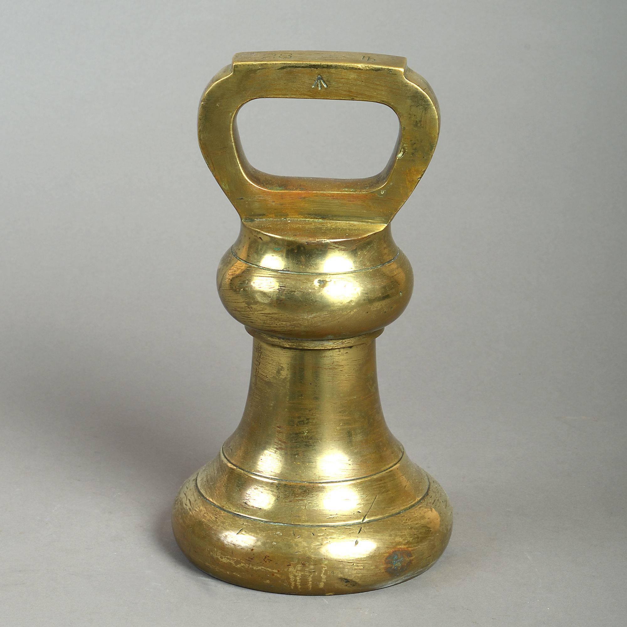 A large mid-19th century brass bell weight, the handle inscribed 28 lb and with a pheon. 

Brass bell weights were produced for official use throughout Great Britain and the British Empire in the 19th century. The inscribed pheon was applied to