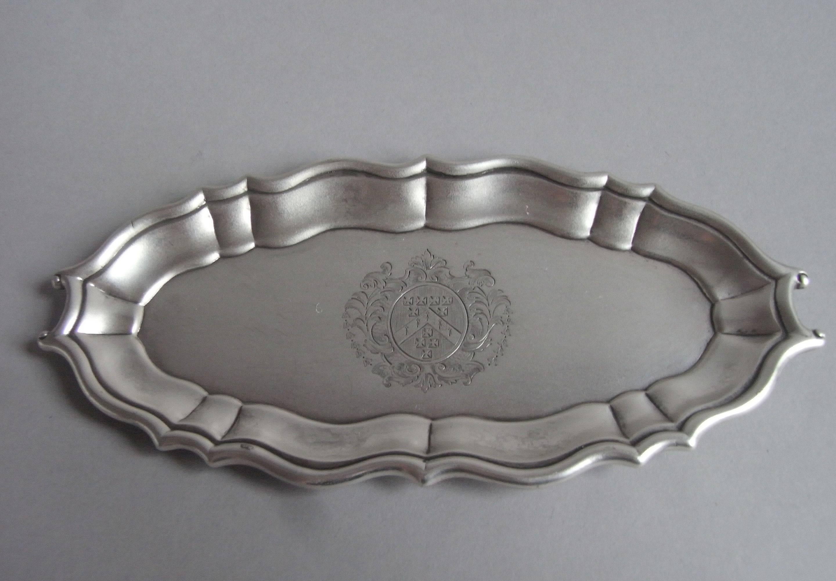 The spoon tray is shaped oval in form with a raised panelled rim, with scrolls at each end for carrying. The centre of the tray is finely engraved with a contemporary Armorial surrounded by a beautiful cartouche of foliate garlands, bluebells and