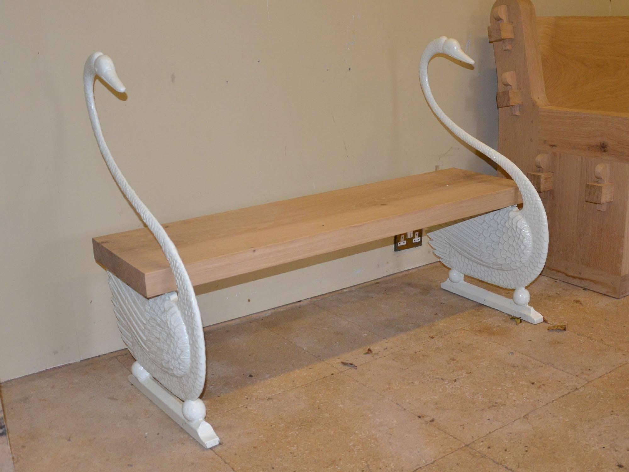 Having a replacement oak bench supported by a pair of elegant cast iron swans.