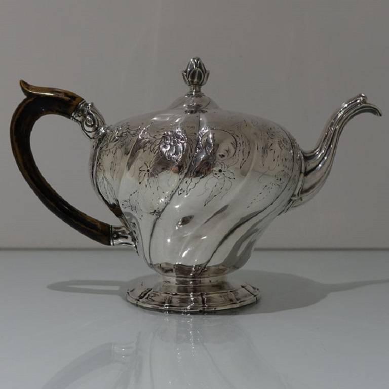 A stunning quality 18th century European teapot with flush hinged lid. The pot is inverted pear shaped with a spiral fluting design to the body which has been elegantly floral engraved for highlights. 

Measure: The length is 28 cm.