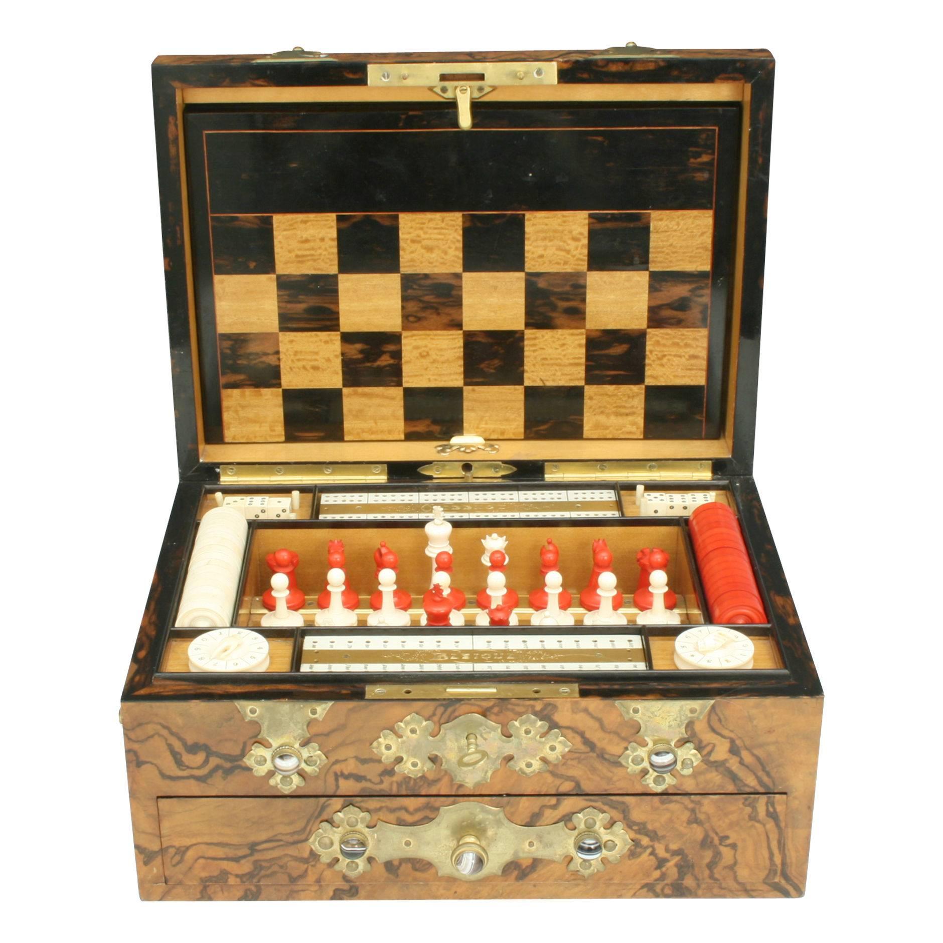 Victorian Games Compendium.
A fabulous antique games compendium made with the most beautiful rich walnut, satin wood, ebony and rose wood, decorated with gilt work encrusted with marbles. The compendium consists of chess, backgammon, draughts,