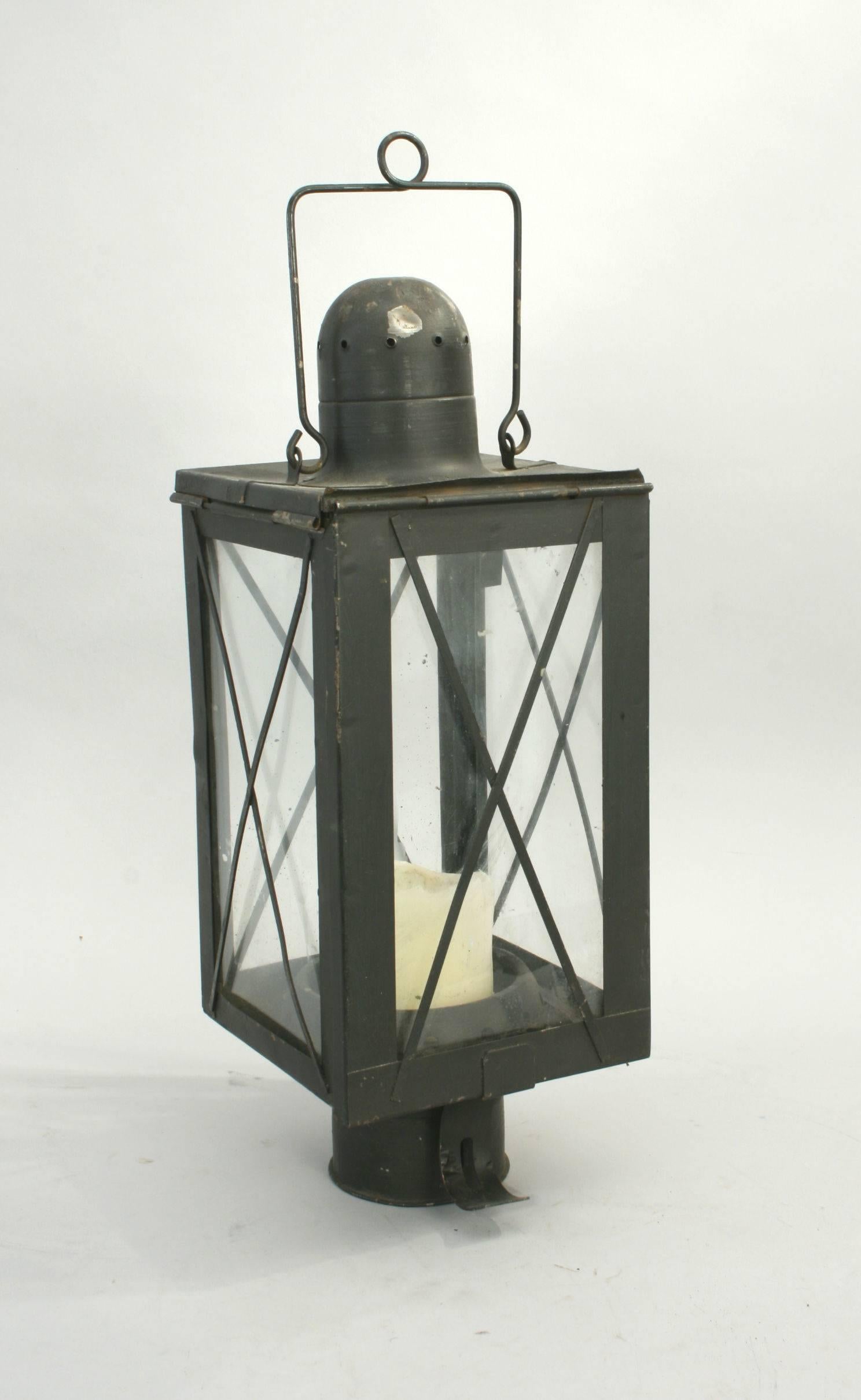 Vintage metal lantern.
A good metal lantern with a black paint finish. The candle flame is protected by glass panels on all four sides. There is a hinged door to the front and a carry handle to the top. The glass is protected by diagonal metal