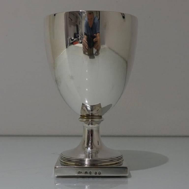 A splendid looking plain formed early Georgian wine goblet sitting on a stylish raised circular pedestal foot which is then mounted on a silver square plinth for artistic design. The inside of the bowl is gilt.