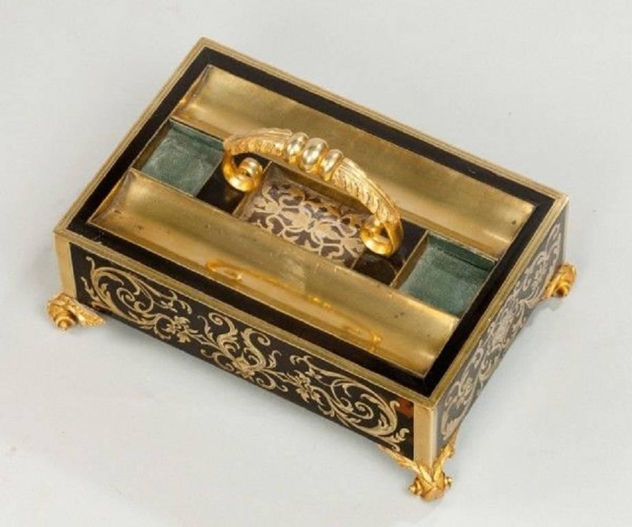 A brass and tortoiseshell pen tray with a C-scroll handle, scroll feet and boulle work decoration.