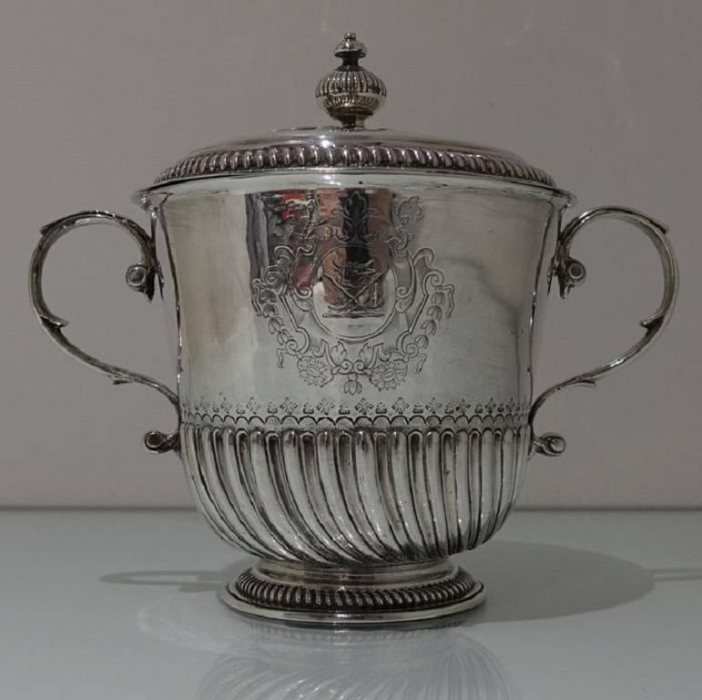 A very elegant half spiral fluted porringer and cover with applied scroll handles. The centre front of the body has a stunning contemporary armorial for importance. The lid is detachable with additional inner and outer bands of spiral fluting for