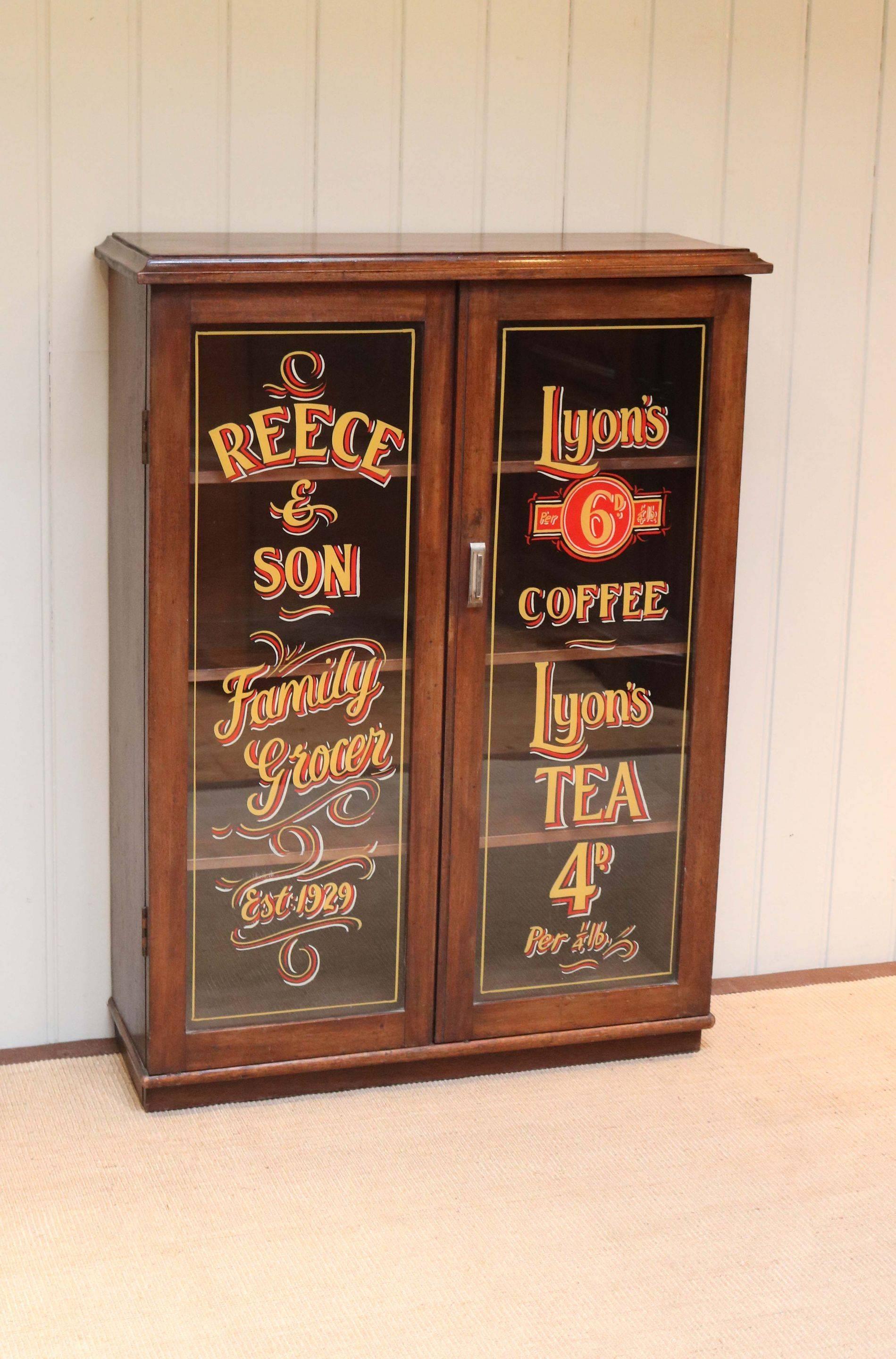 Unusual mahogany shop display bookcase having two glazed sign written doors with three fixed internal shelves raised on a plinth base. The depth of the shelves is 21cm and the height between each is 22.5 cm.