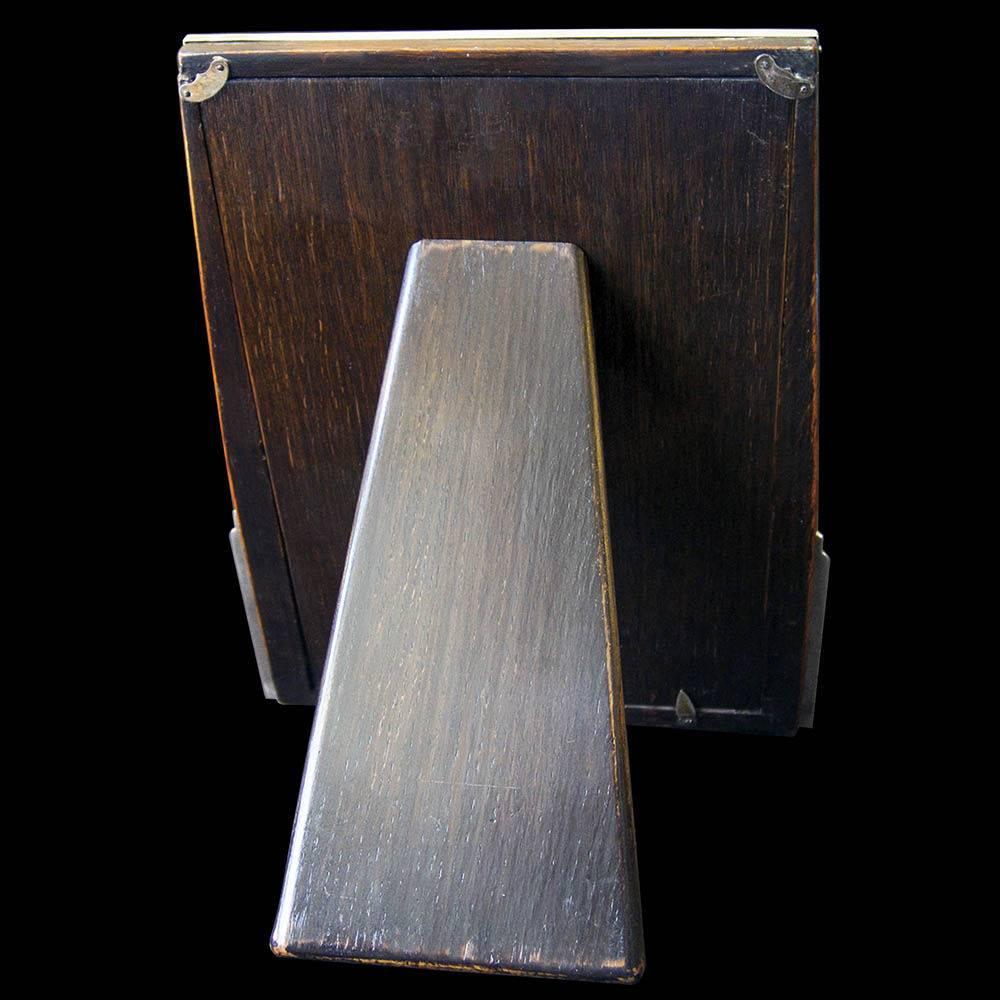 A stylish Art Deco photograph frame with engine turned decoration, having a wooden easel back designed to stand the frame in a portrait orientation. The outer edges of the silver frame tapered towards the top.

Deakin & Francis is the oldest family
