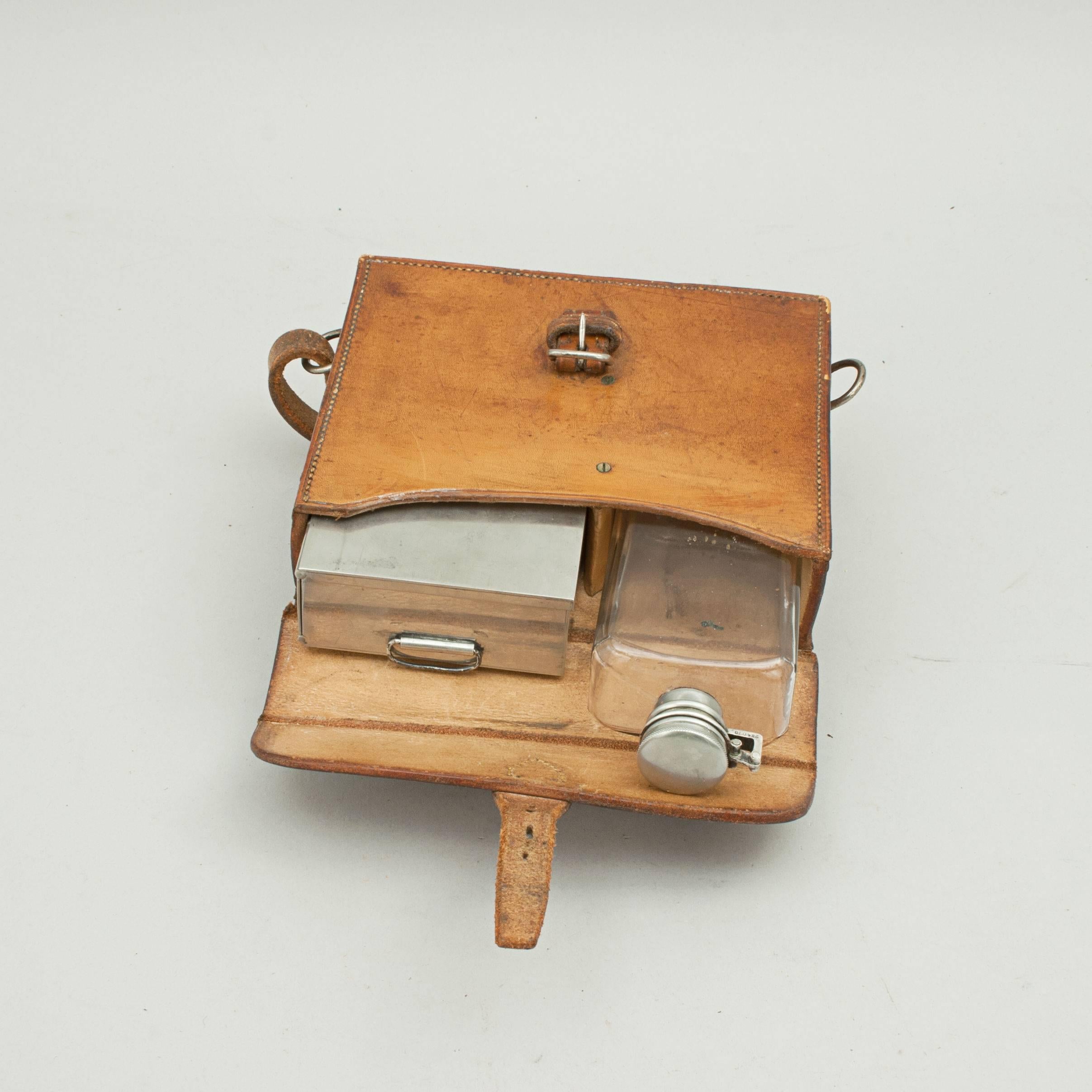 Hunting flask with Sandwich case. 
A very nice hunting flask and sandwich box in a leather saddle case. The electro-plated sandwich box has a fall-down back and ring pull handle. The case is with saddle straps and the leather lid closes with a