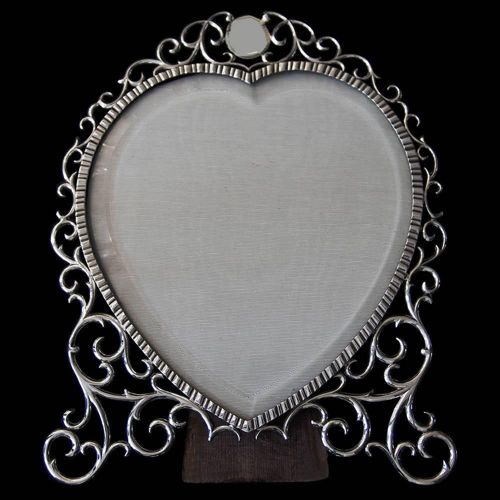 An unusual heart shaped frame with wooden easel back stand. The wraparound frame decorated with a decorative cast border having a circular vacant cartouche at the top.