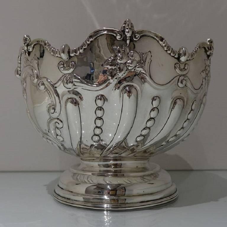 A beautifully designed mid sized circular silver rose bowl decorated with elegant swirl fluting and bead designs. The edge of the rim is wavy and has figural motifs for highlights.