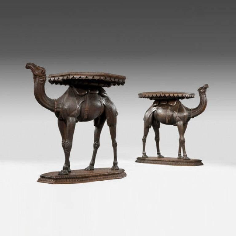 Each of these teak tables is in the form of a standing camel with an 
octagonal tray on its back. The body is carved with naturalistic hair. 
Anglo Indian, circa 1890.