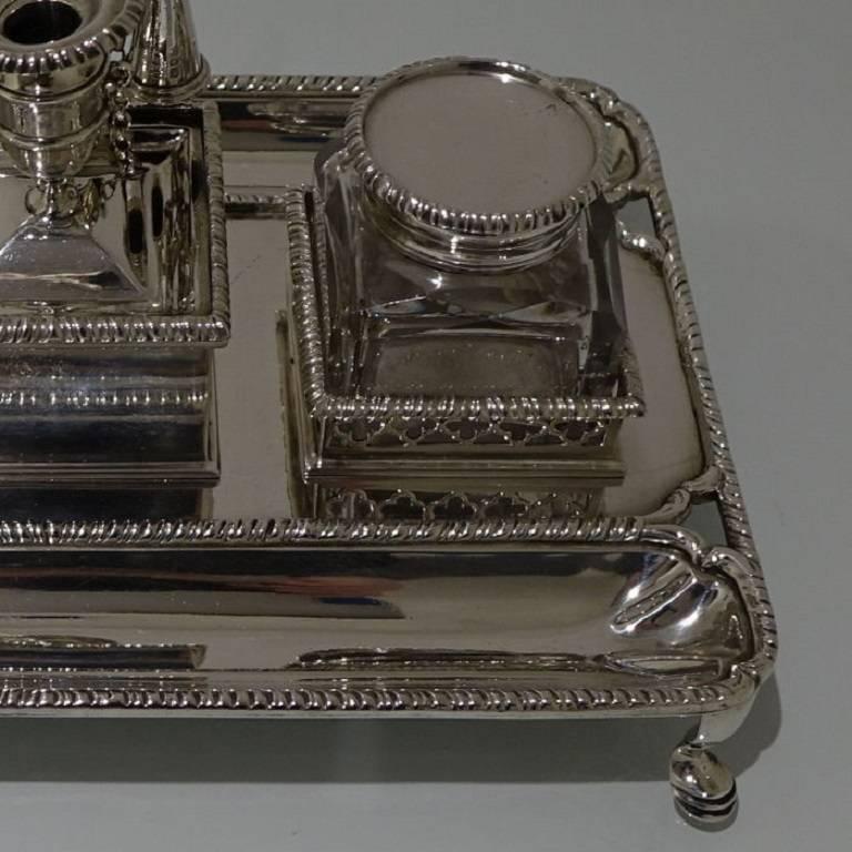 A very elegant Victorian silver desk inkstand with double pen tray for easy use from either side of a desk. The inkstand has decorative bordering throughout for highlights and sits on four stylish feet. The inkwells sit in ornate pierced gallery